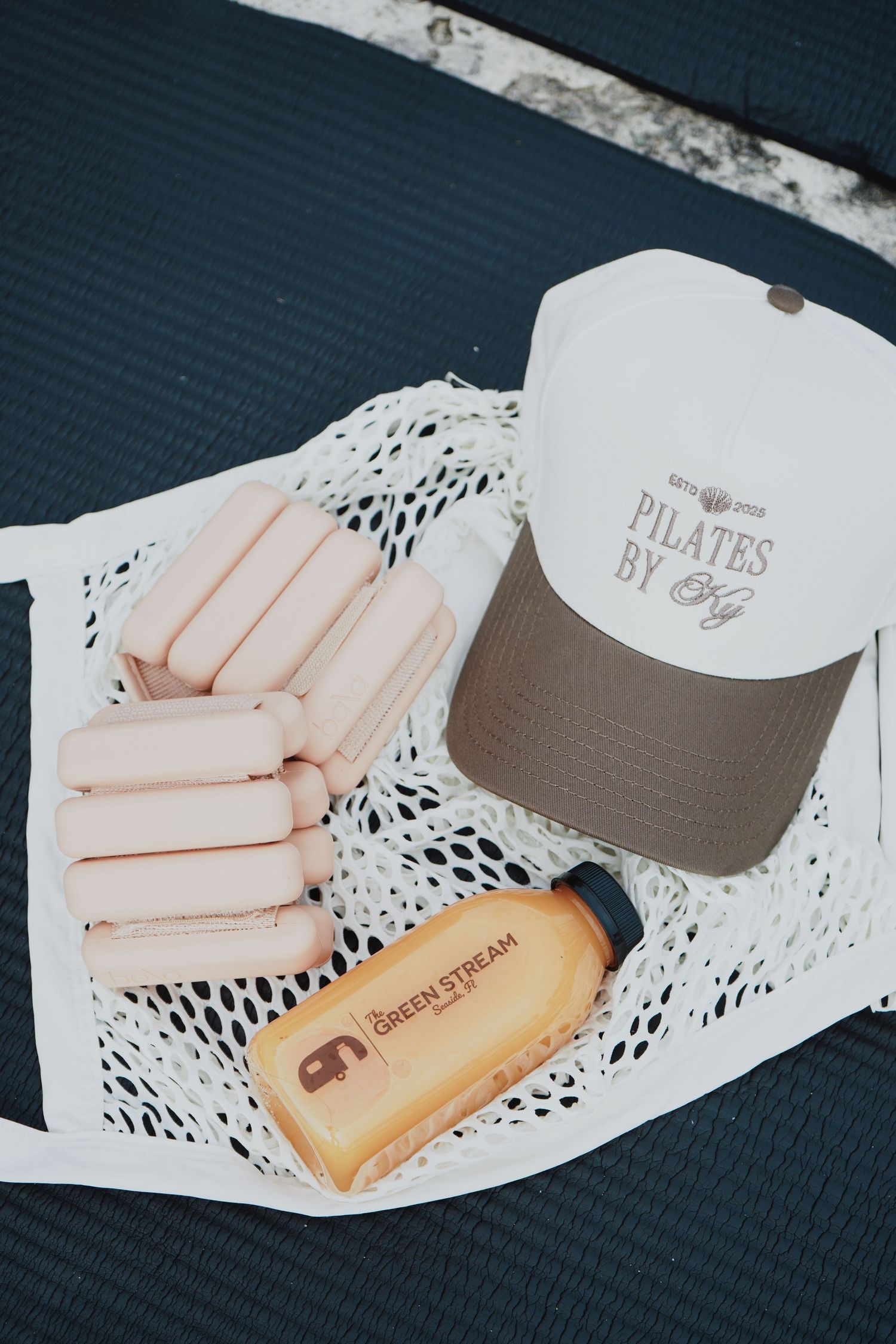 Pilates equipment and accessories displayed on white lace doilies against a navy blue background.