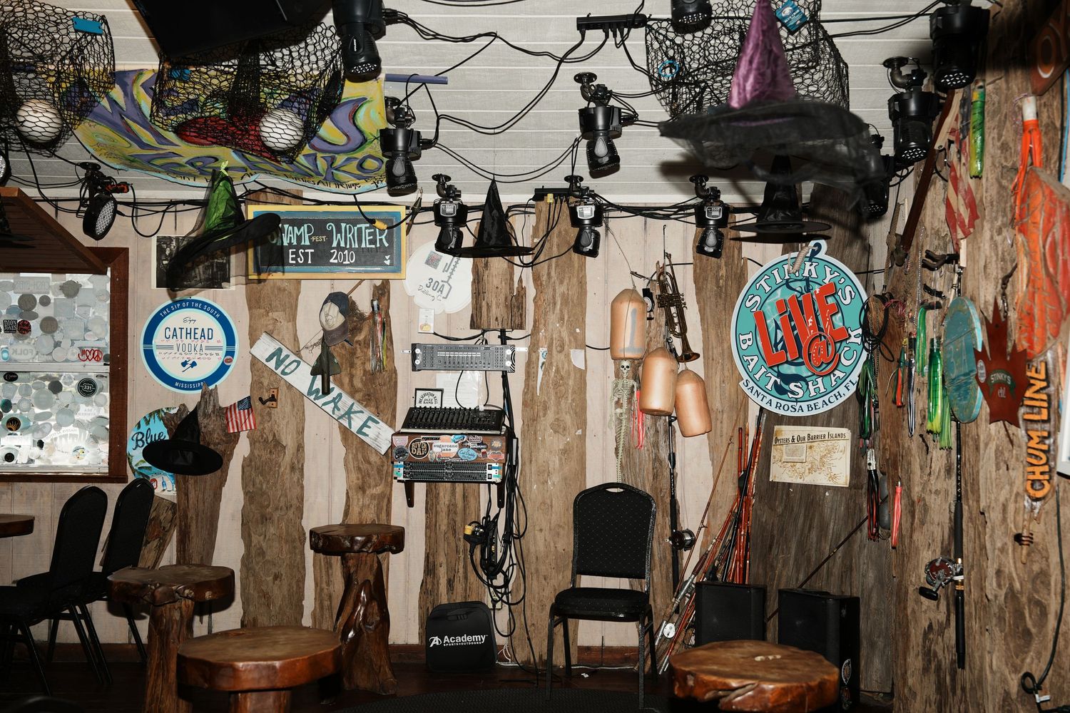 A cluttered dive bar interior with vintage decorations, signs, and memorabilia hanging from the walls and ceiling.