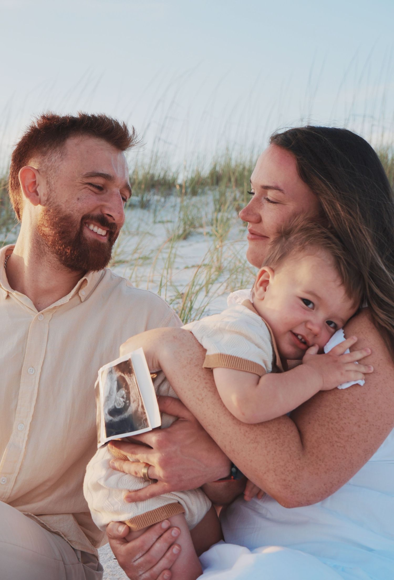 A family shares joyful candid moments together on a white sandy beach in a series of connected photos.