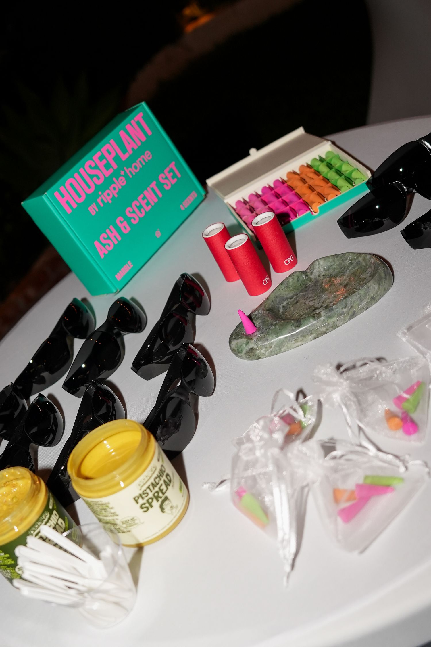Colorful drink mix packets and plastic cups lined up on a white surface with measuring tools.