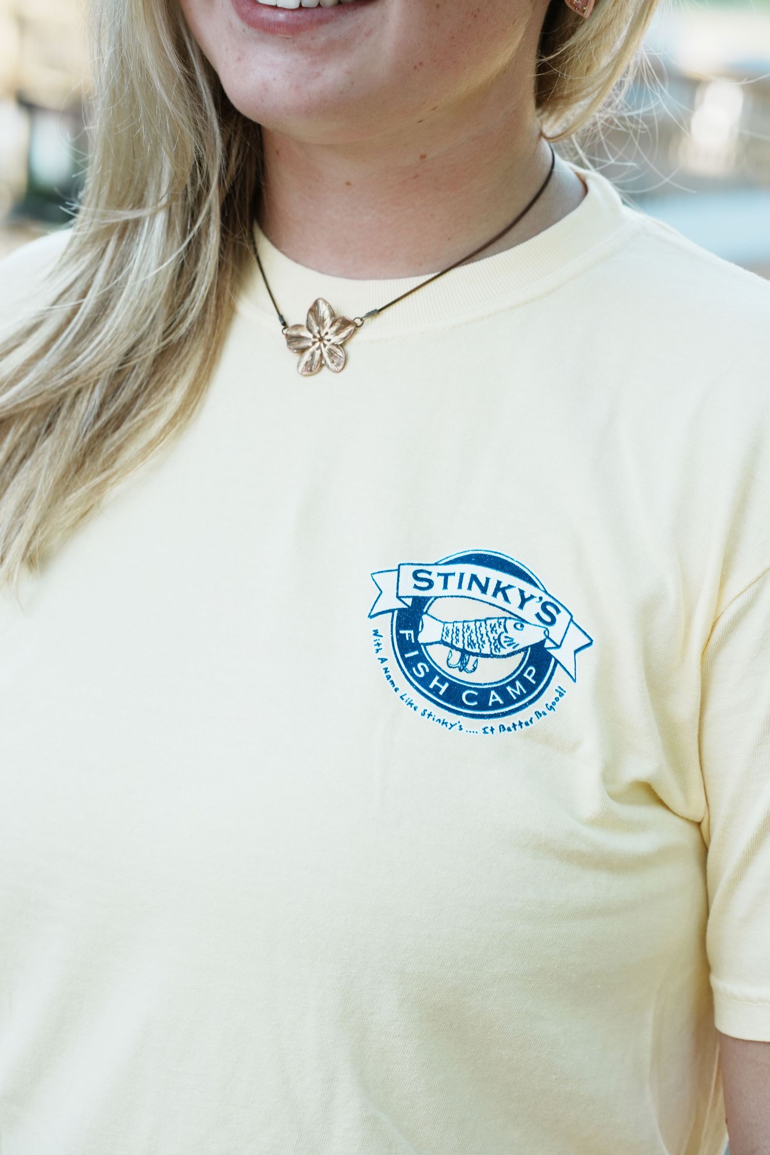 Cream colored t-shirts displayed in sequence showing a blue fish logo design.