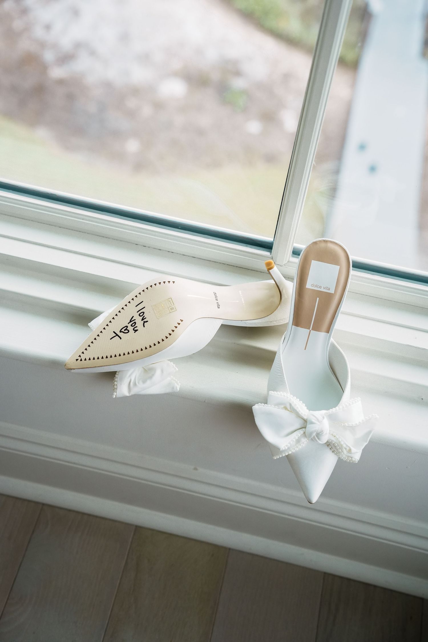 A white origami paper boat sits on a window sill in natural light creating a peaceful minimalist scene.