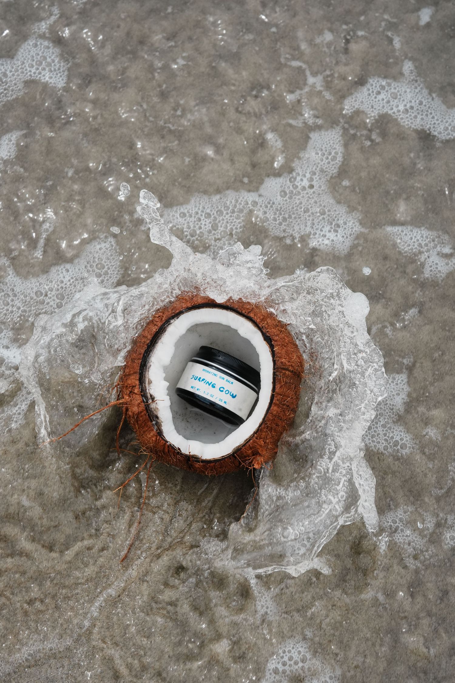 An image from a brand coastal photoshoot of an organic sunscreen brand in the ocean.