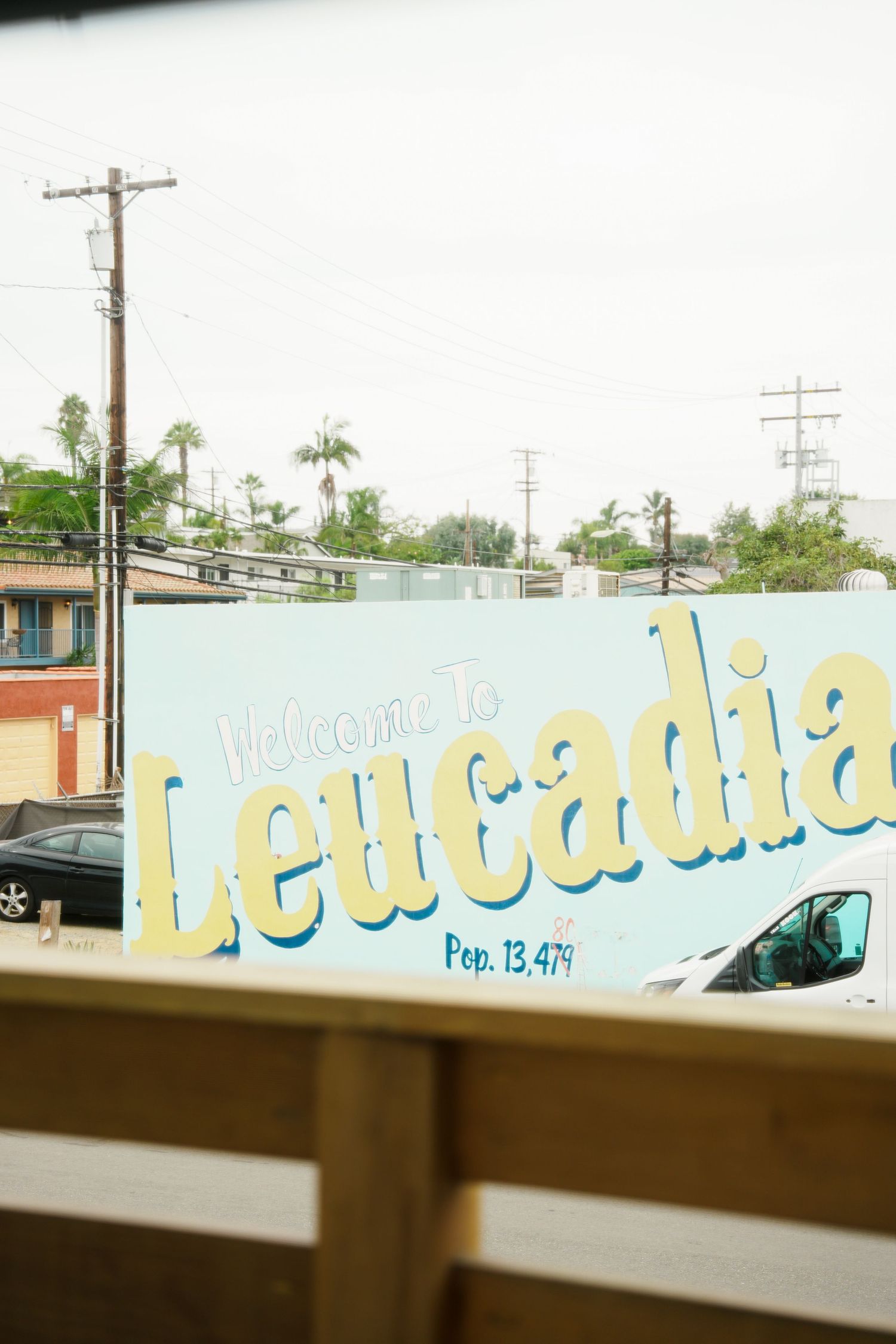 A sequence of five photos showing a blue lettering sign on a wall viewed through a car window.