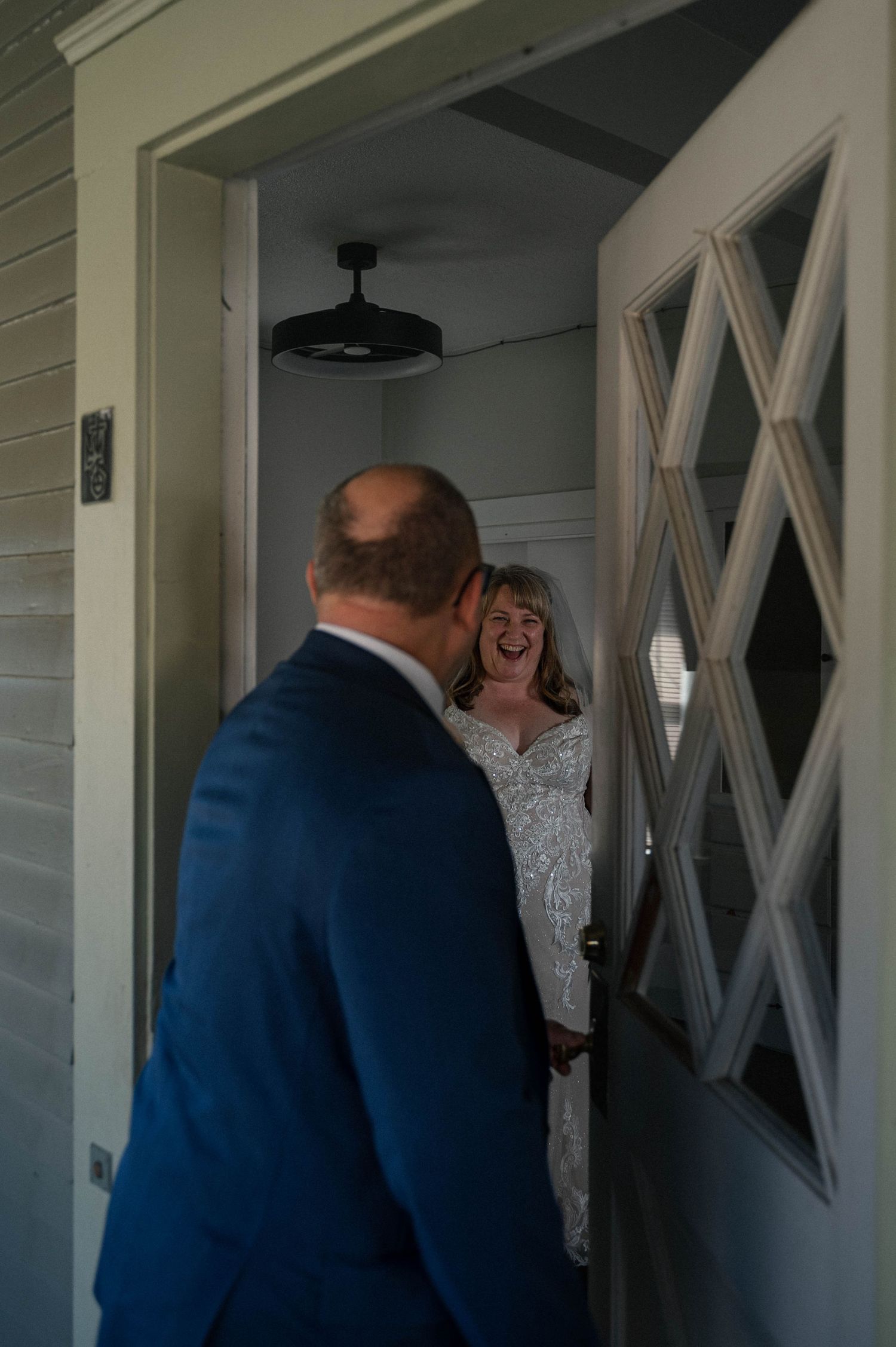 A series of three photos showing a joyful first look moment between a bride and groom in a white hallway.