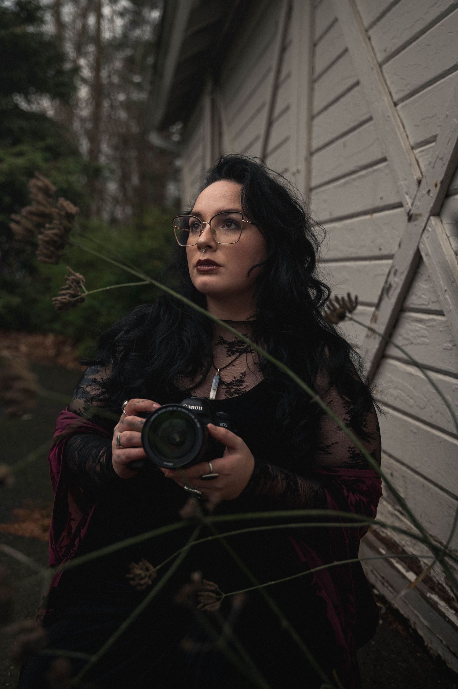A gothic-styled portrait series against a white wall showcases dark fashion and dramatic poses in moody lighting.