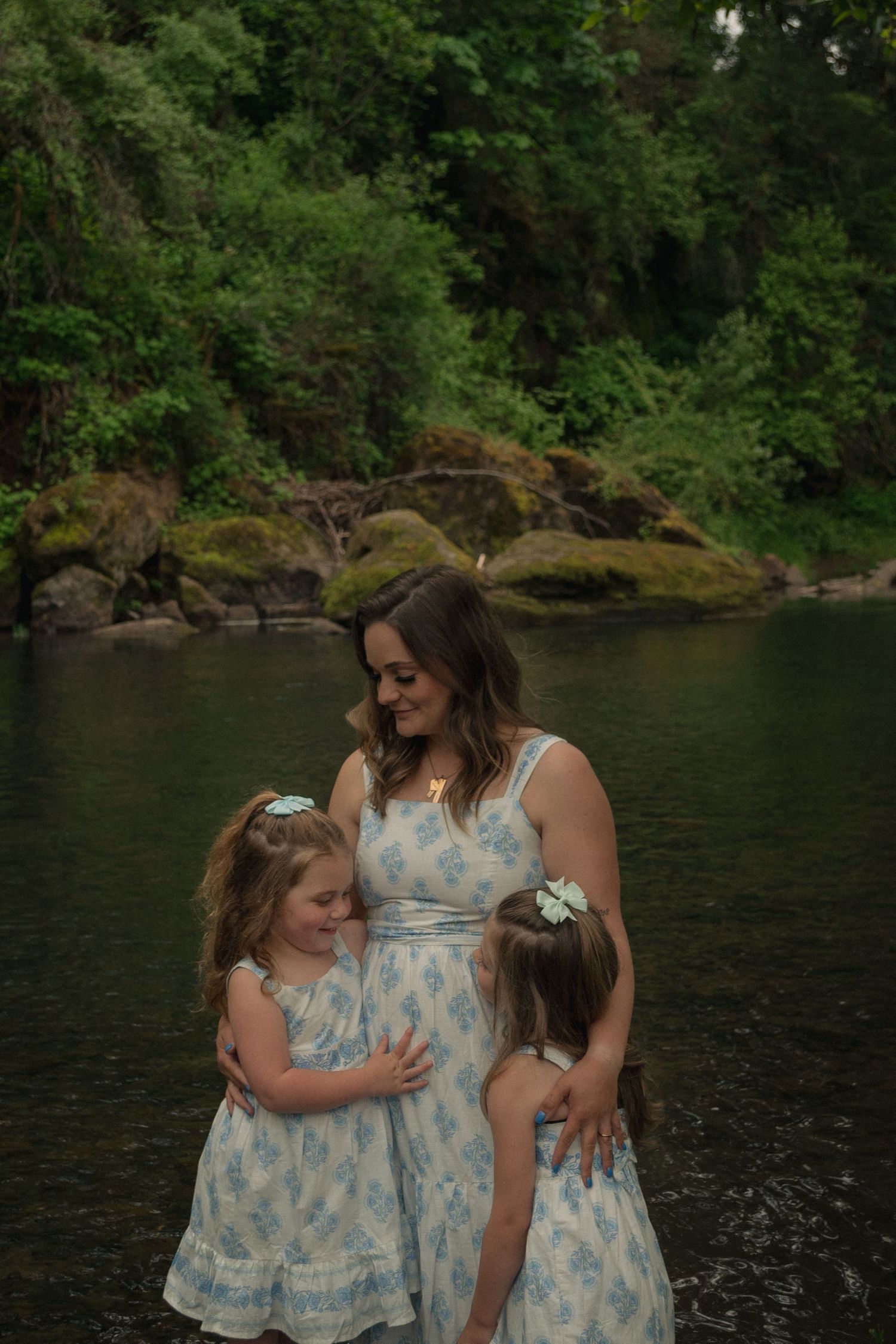 Mother holding her young daughters by Thomas Creek in Scio by Moon Street Photography