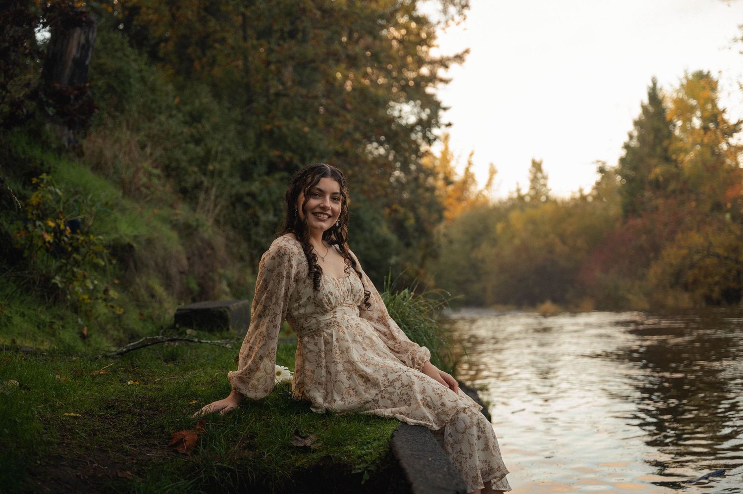 Girl sitting next to creek, dipping her feet in the water in Silverton, Oregon.