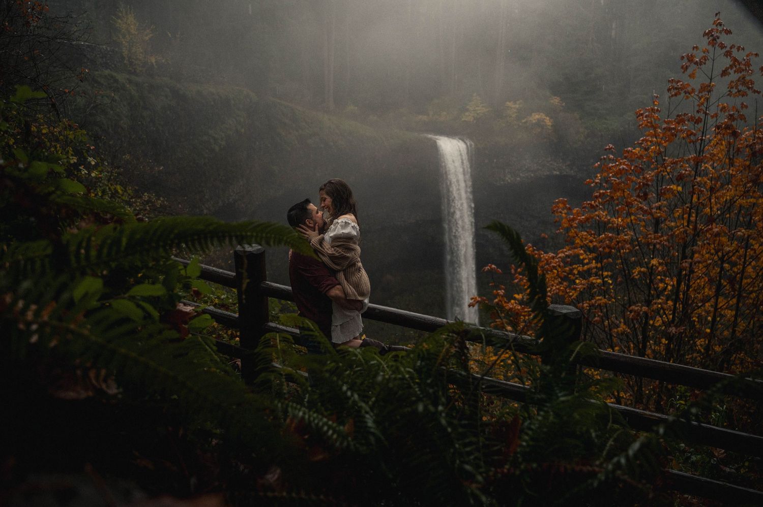 Multnomah Falls waterfall cascades dramatically through autumn foliage in Oregon's Columbia River Gorge.