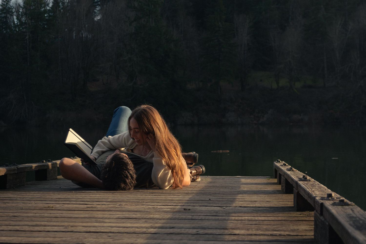 couple reading poetry at the end of the dock, at Silverton Reservoir by Moon Street Photography