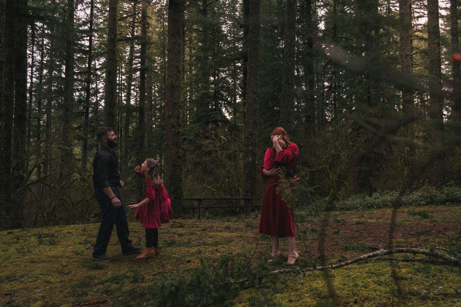 People walking through a misty evergreen forest path.
