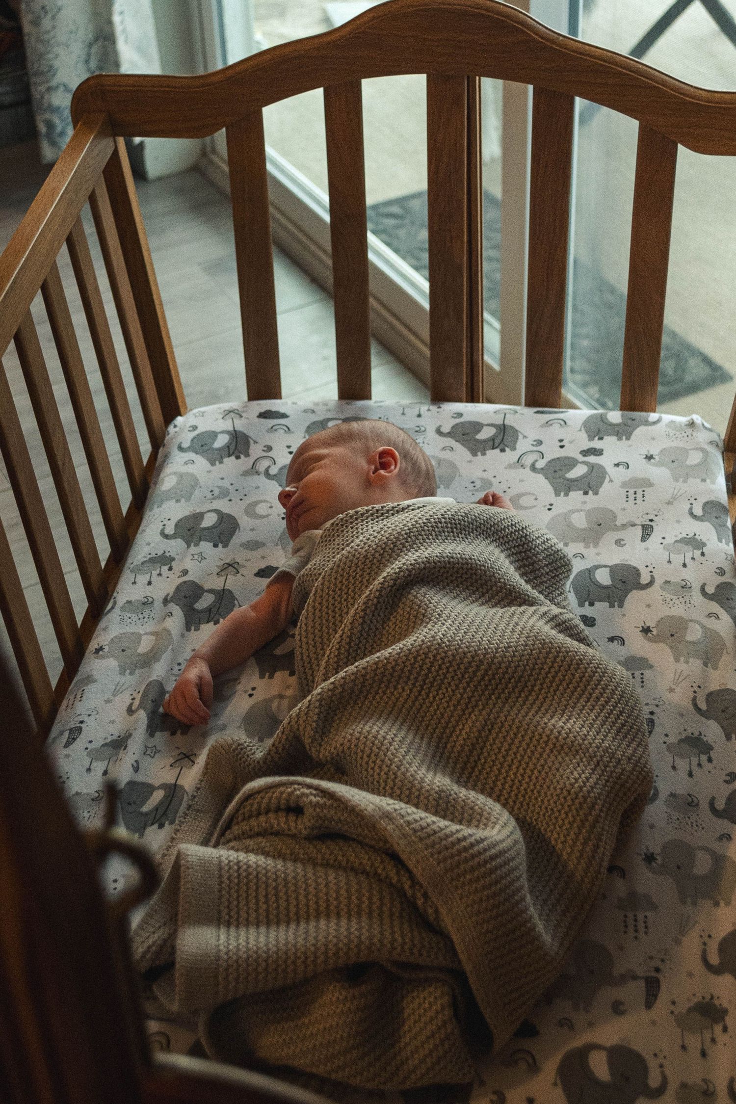 Newborn sleeping peacefully in a hand-made, heirloom crib.