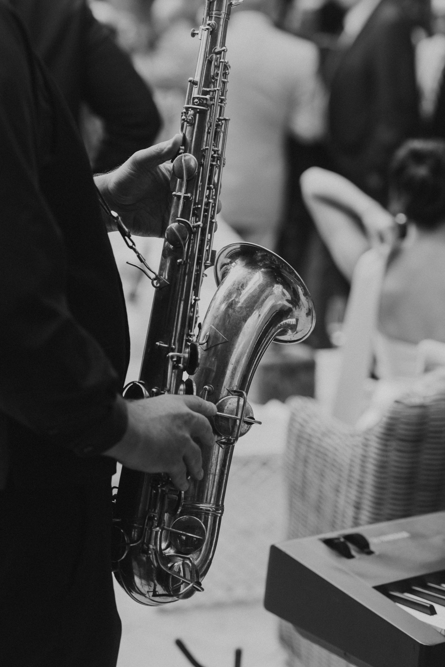 Black and white photo of saxophone player performing at formal event.