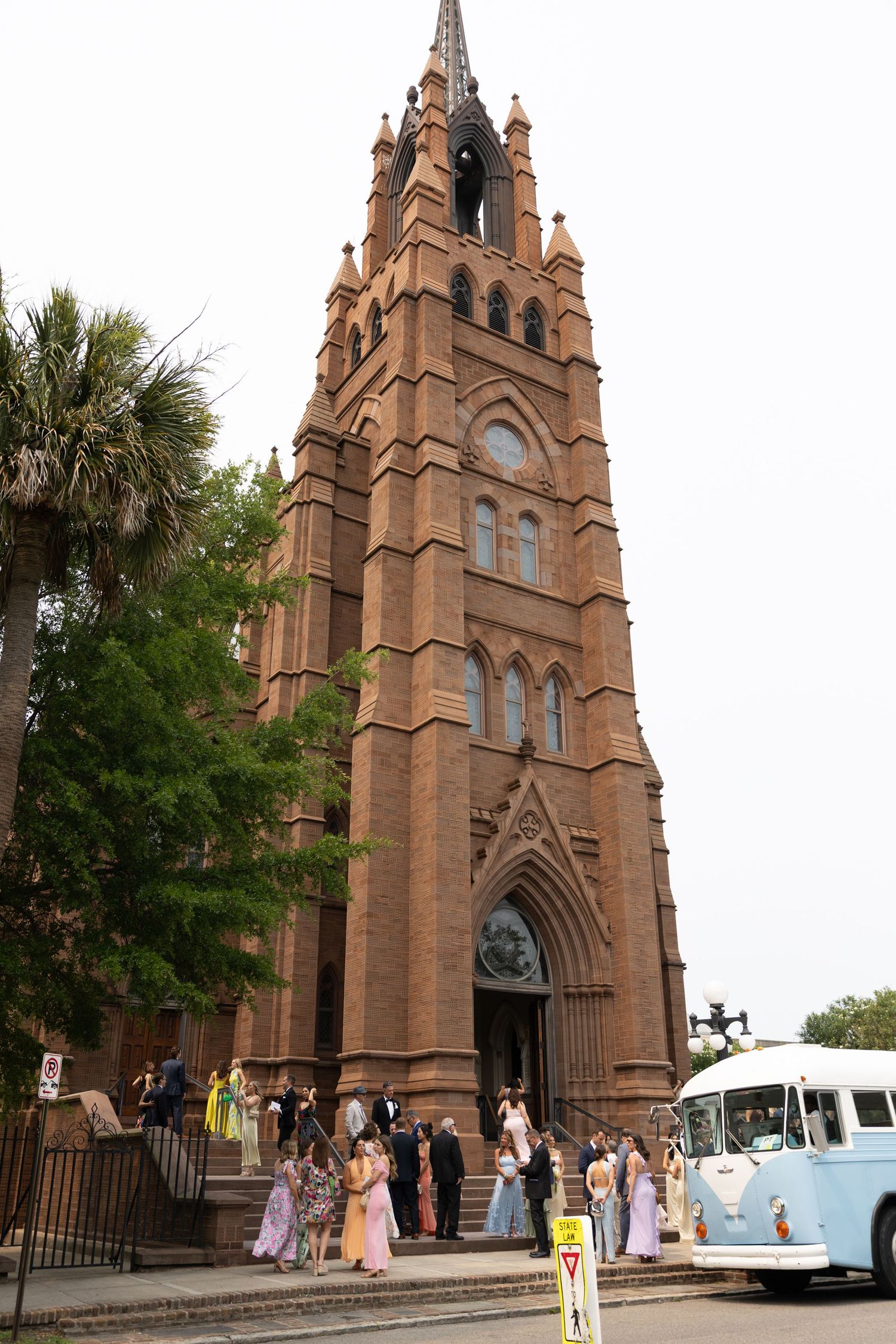 Gothic church exterior with tall spires and arched doorways on wedding day.