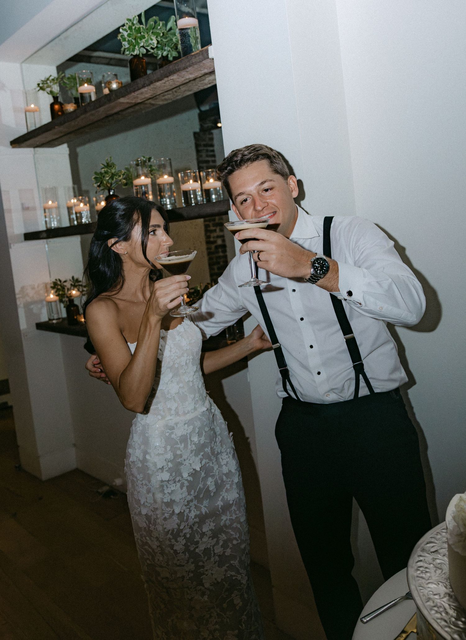 Wedding couple enjoying drinks and laughter during their reception.