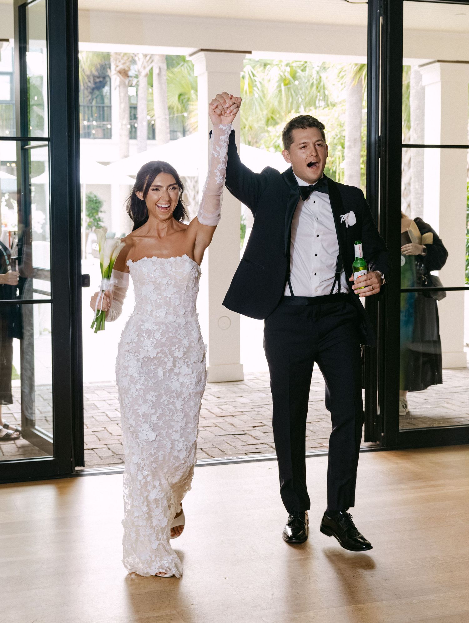 Wedding couple and party members make energetic entrance into reception venue.