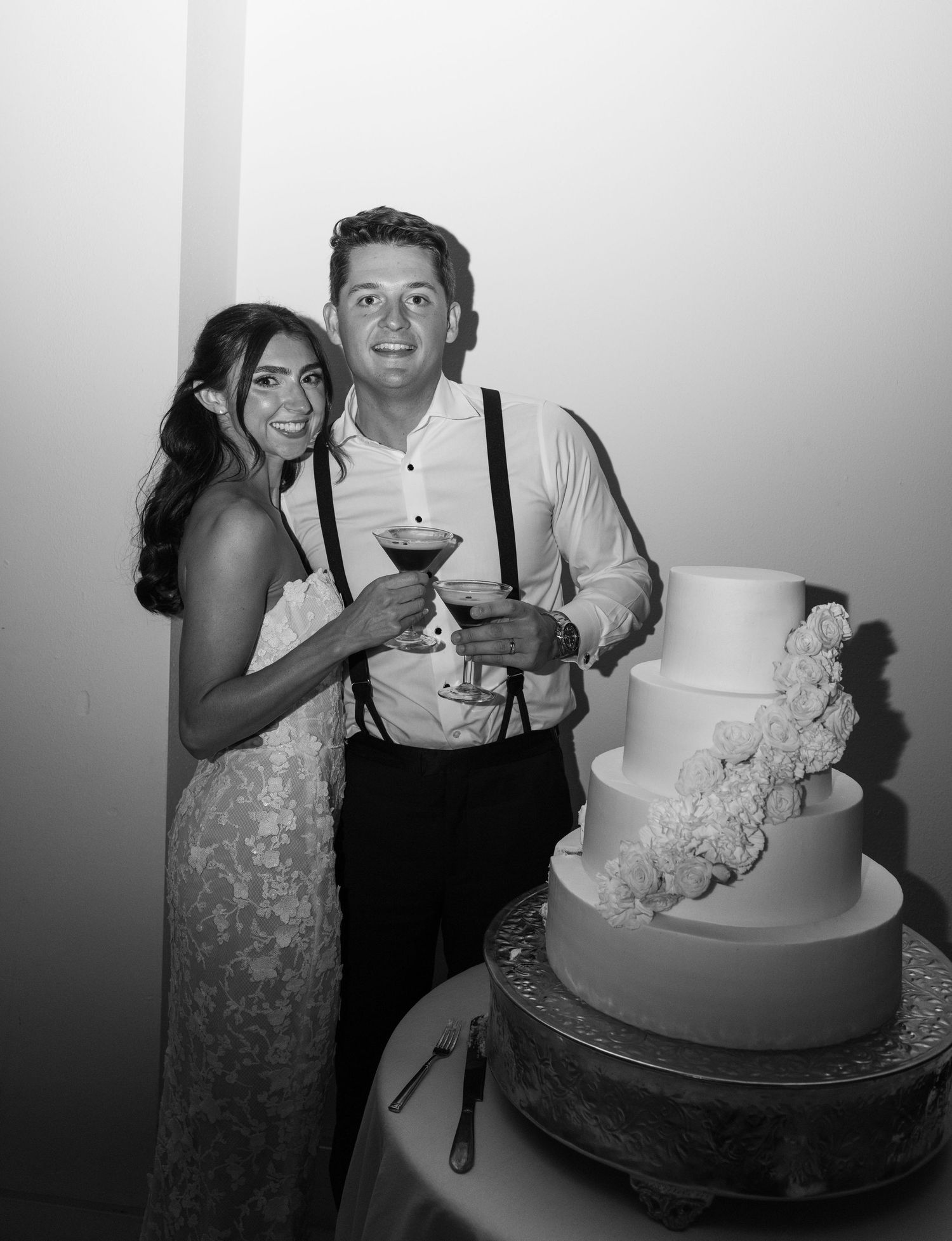 Joyful wedding cake cutting scene with a beautifully decorated white cake.