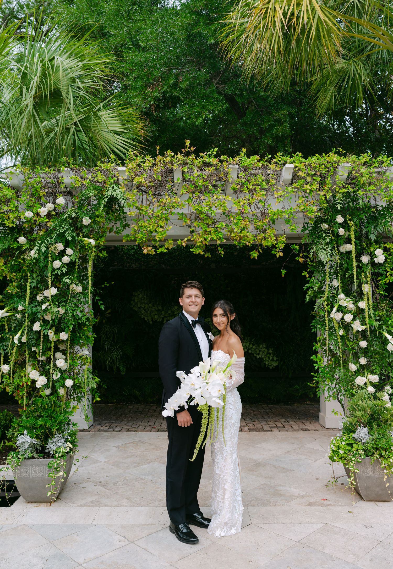 Garden wedding venue decorated with climbing roses and lush greenery creates romantic backdrop.