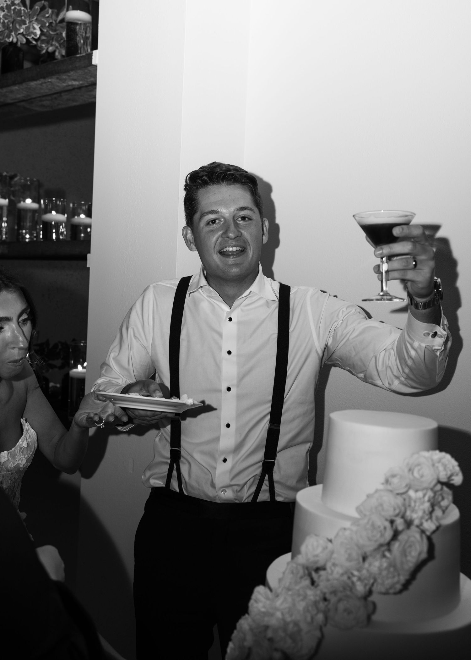 Celebratory moment with champagne glasses and a white tiered wedding cake.