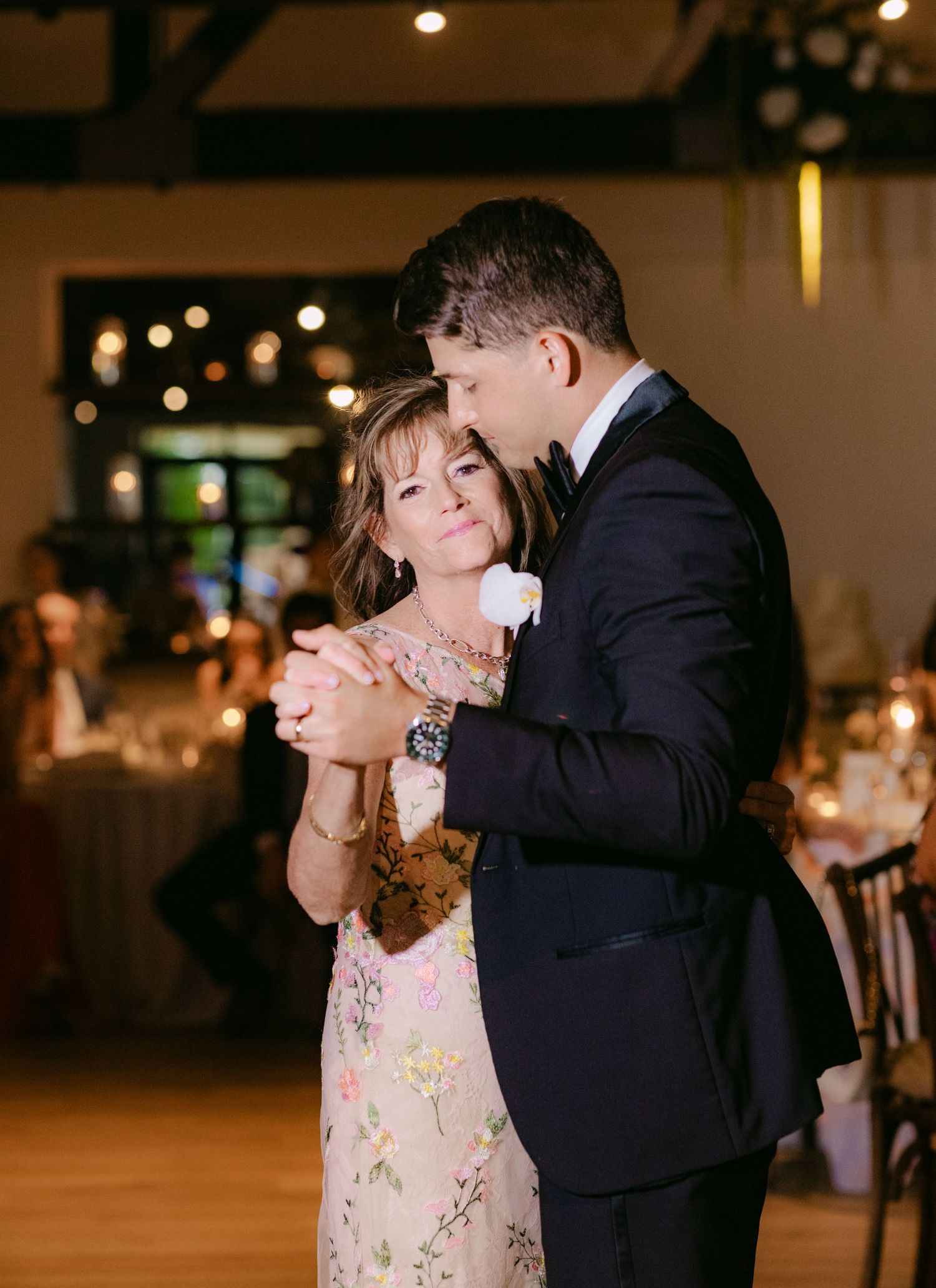 Intimate dance moment captured between couple at evening wedding reception.