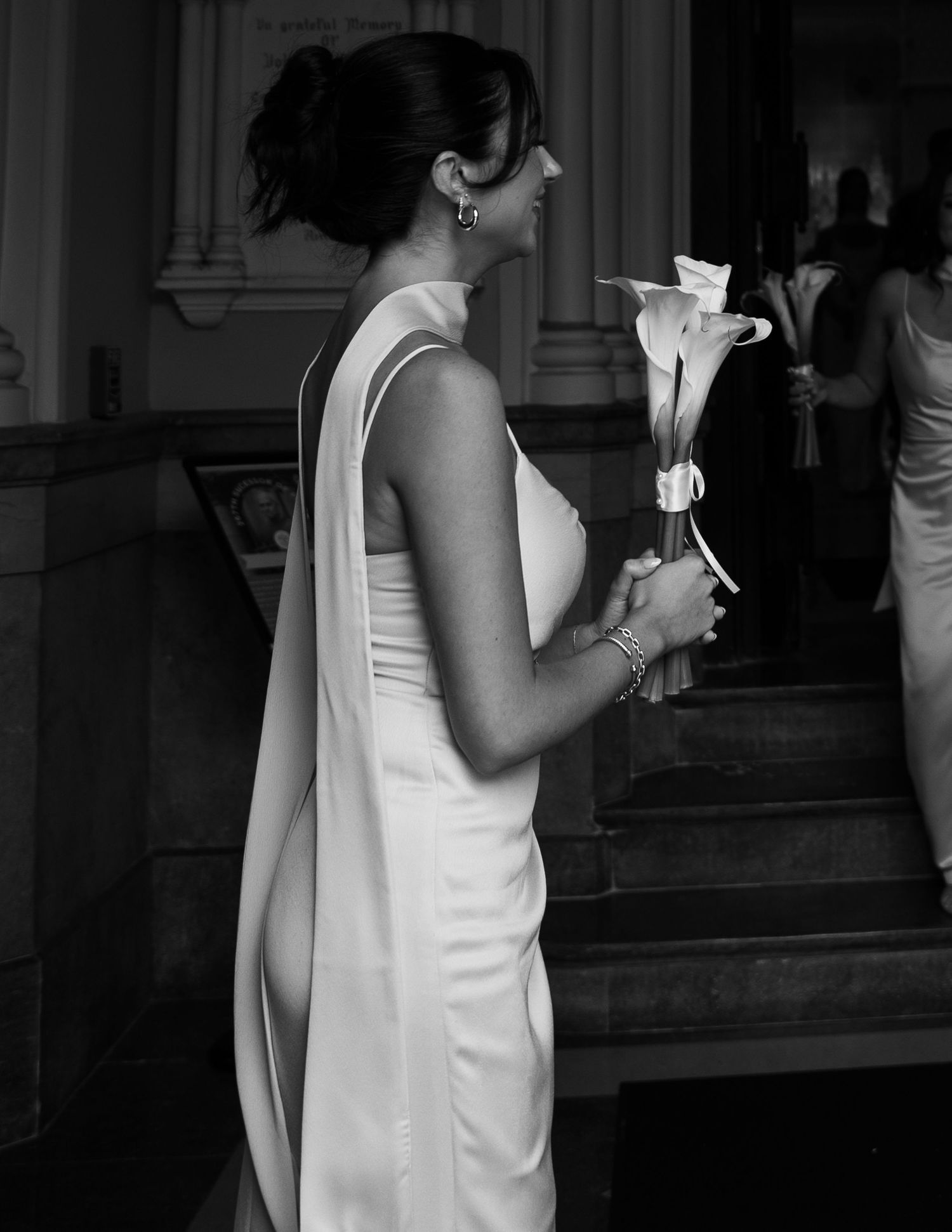Bridesmaids in cream-colored dresses shown in black and white church setting.