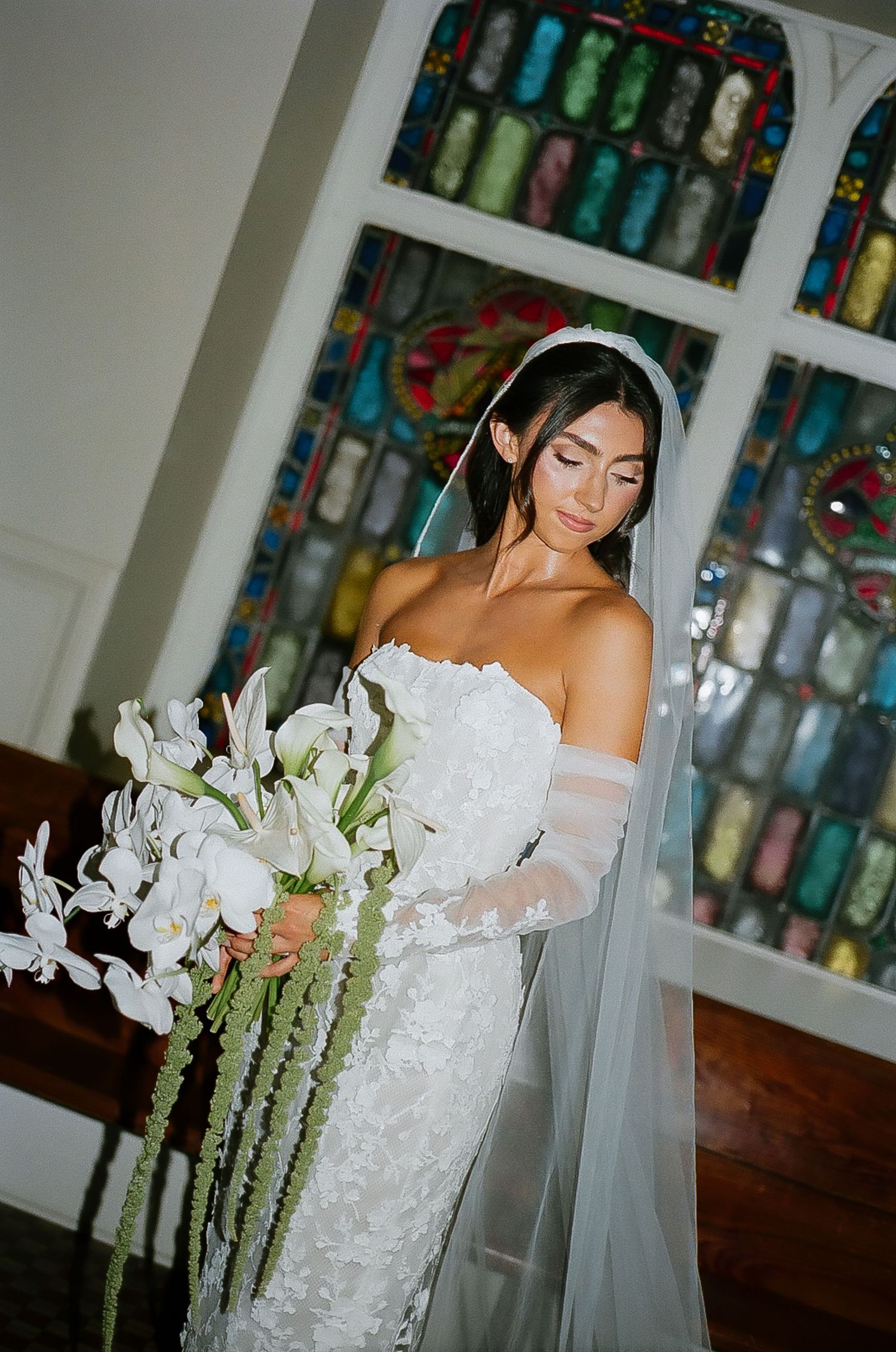 Wedding photos taken in front of colorful stained glass window displays.
