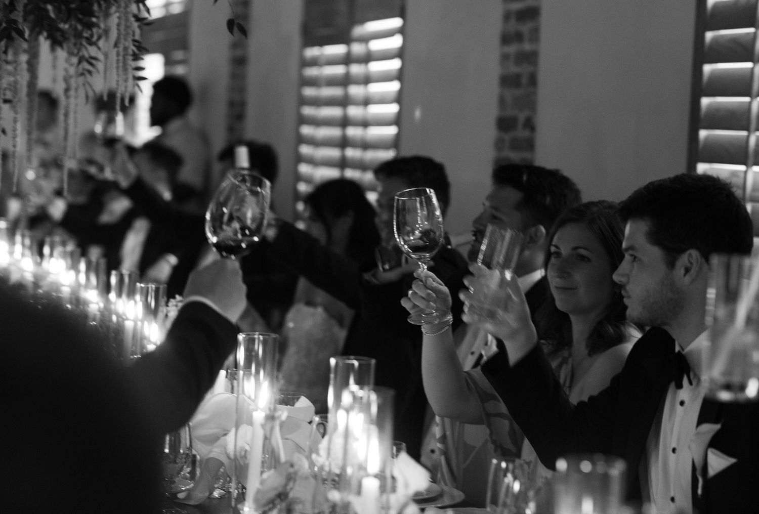 Candlelit reception venue with guests seated at dining tables.