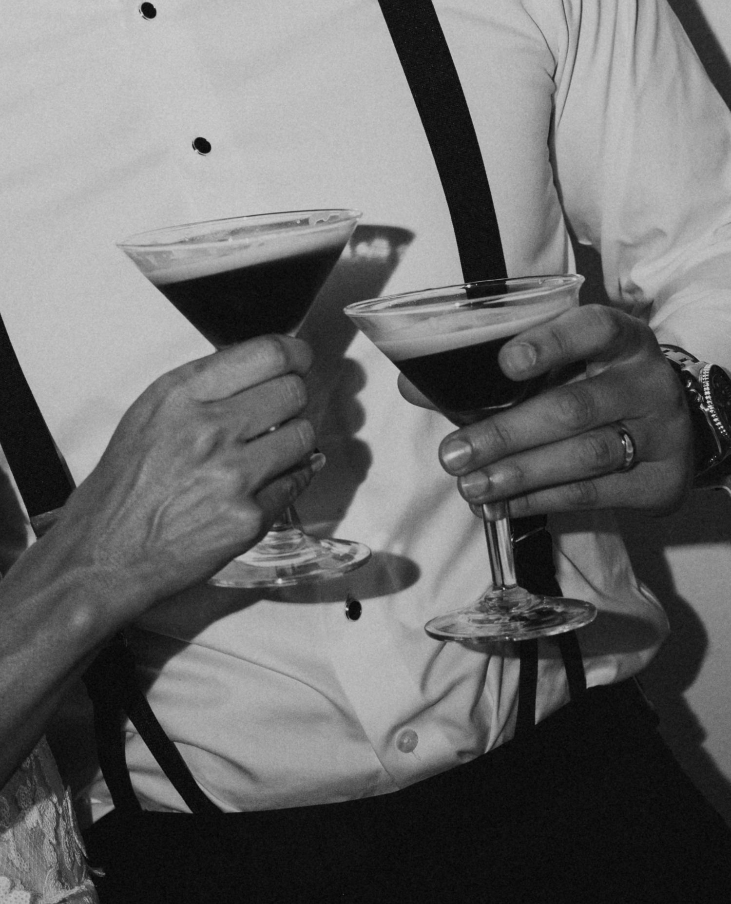 Close-up of hands holding champagne glasses at a wedding celebration.