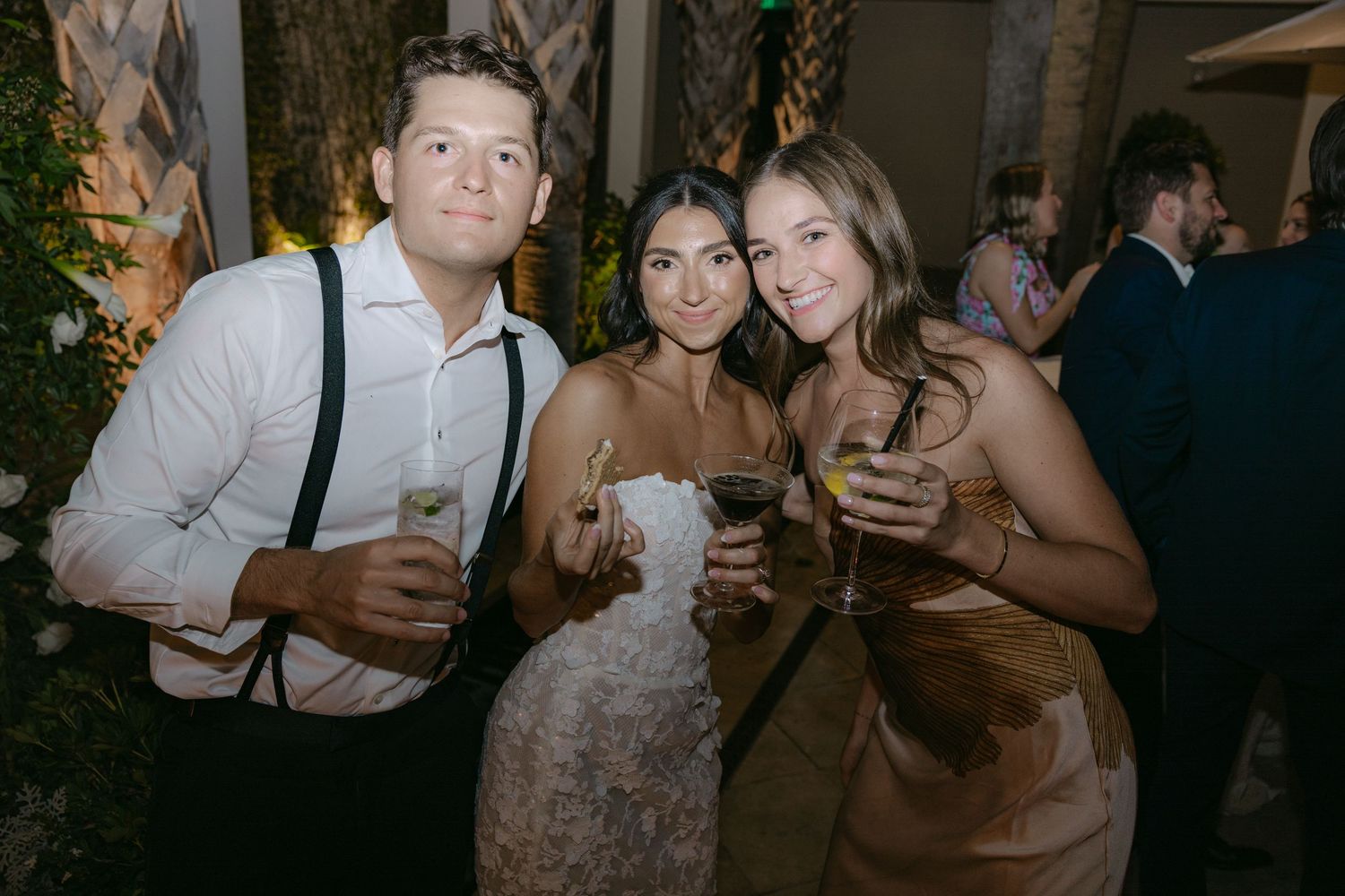 Party guests enjoying drinks and socializing at outdoor wedding reception.