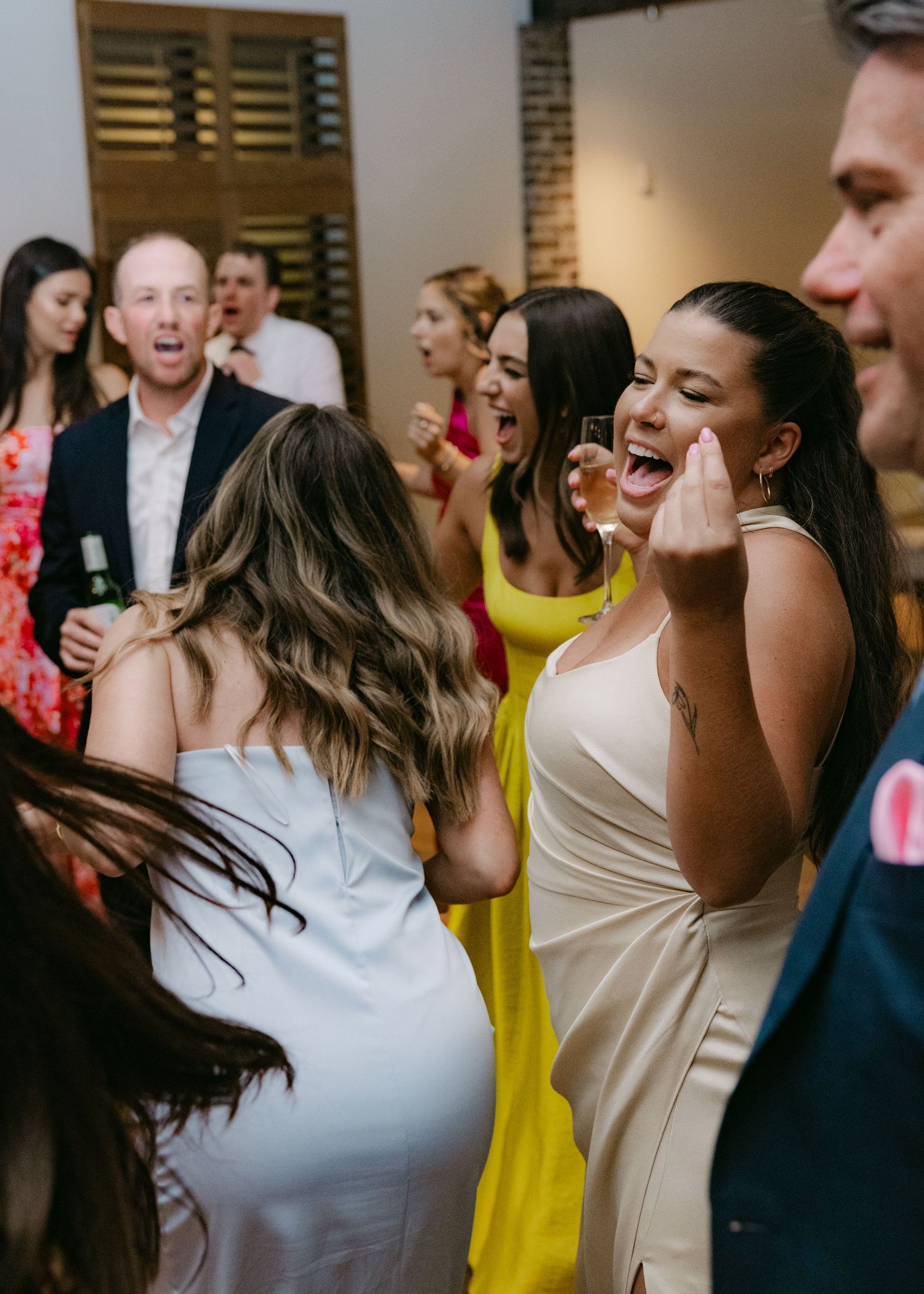 Wedding guests dancing and celebrating at reception party.
