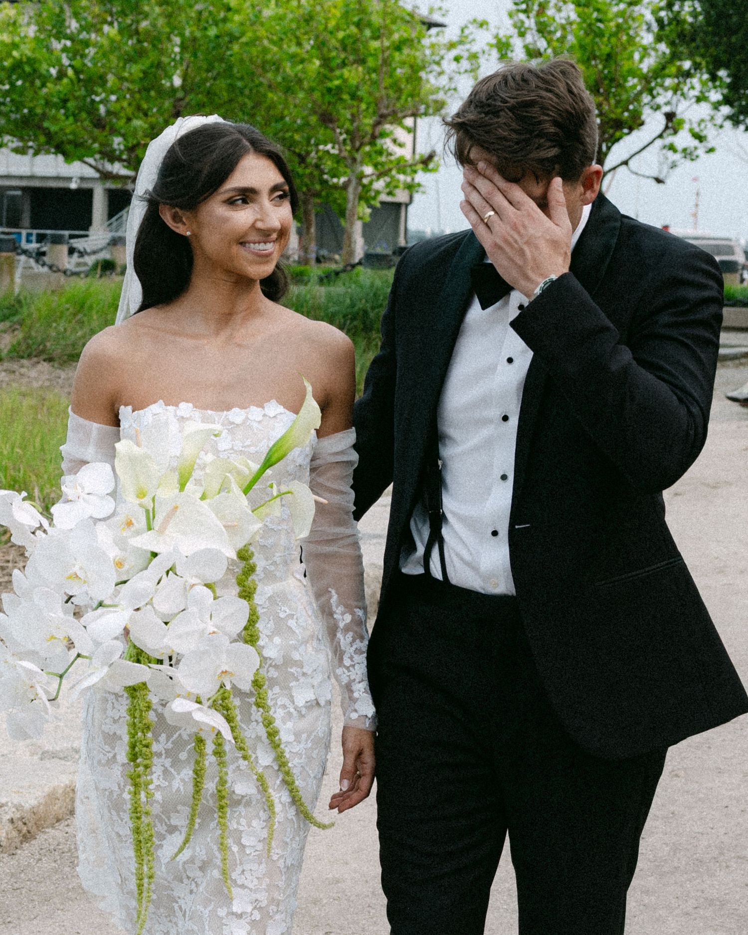 Candid wedding photography capturing natural moments between couple with lush greenery background.
