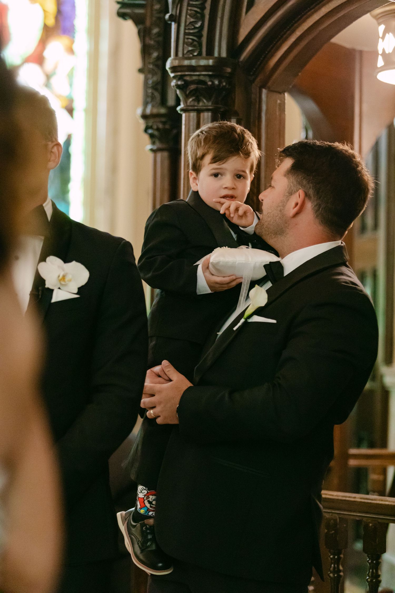 Tender moment shared between family members during formal wedding ceremony.