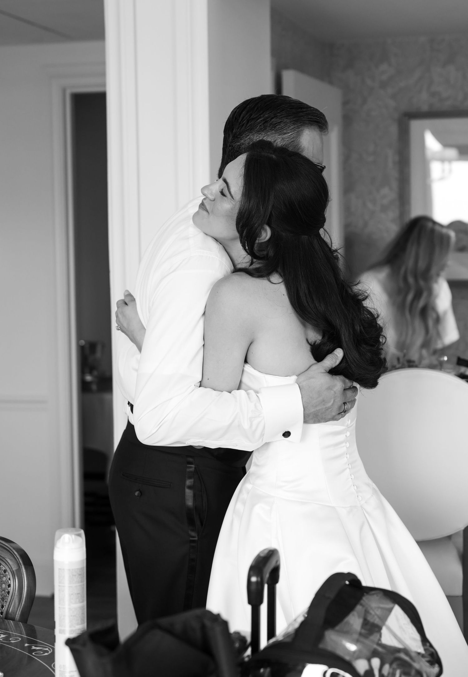 Black and white photo of a bride and groom sharing a tender embrace on their wedding day.