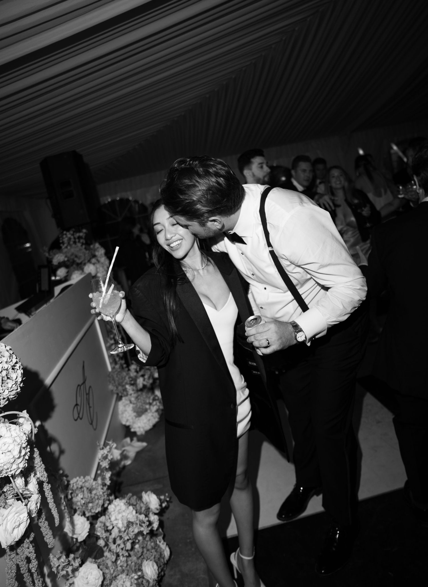 Black and white photo of a couple cutting their wedding cake at an elegant reception venue.