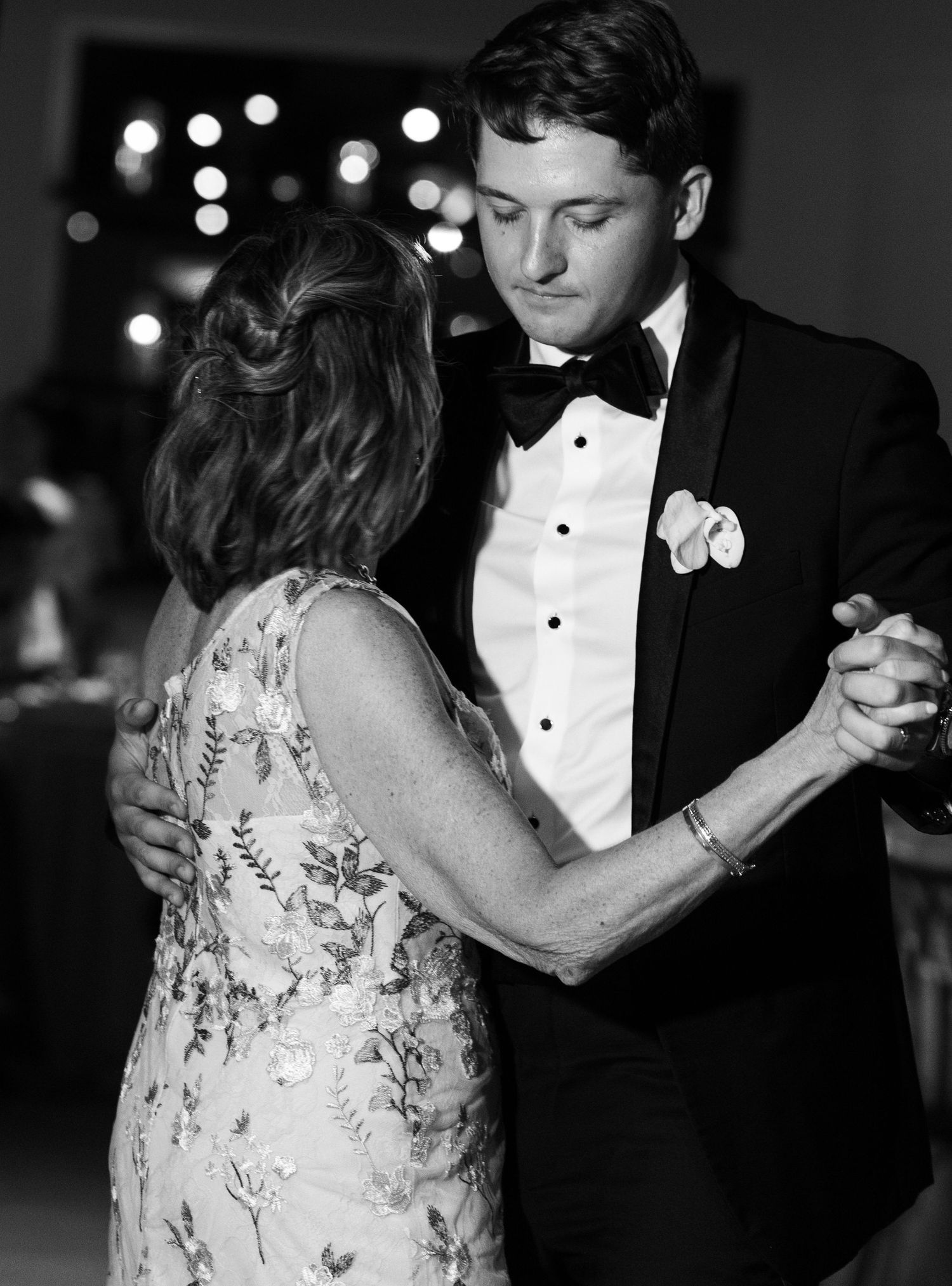 Romantic black and white photo of couple dancing at wedding reception.