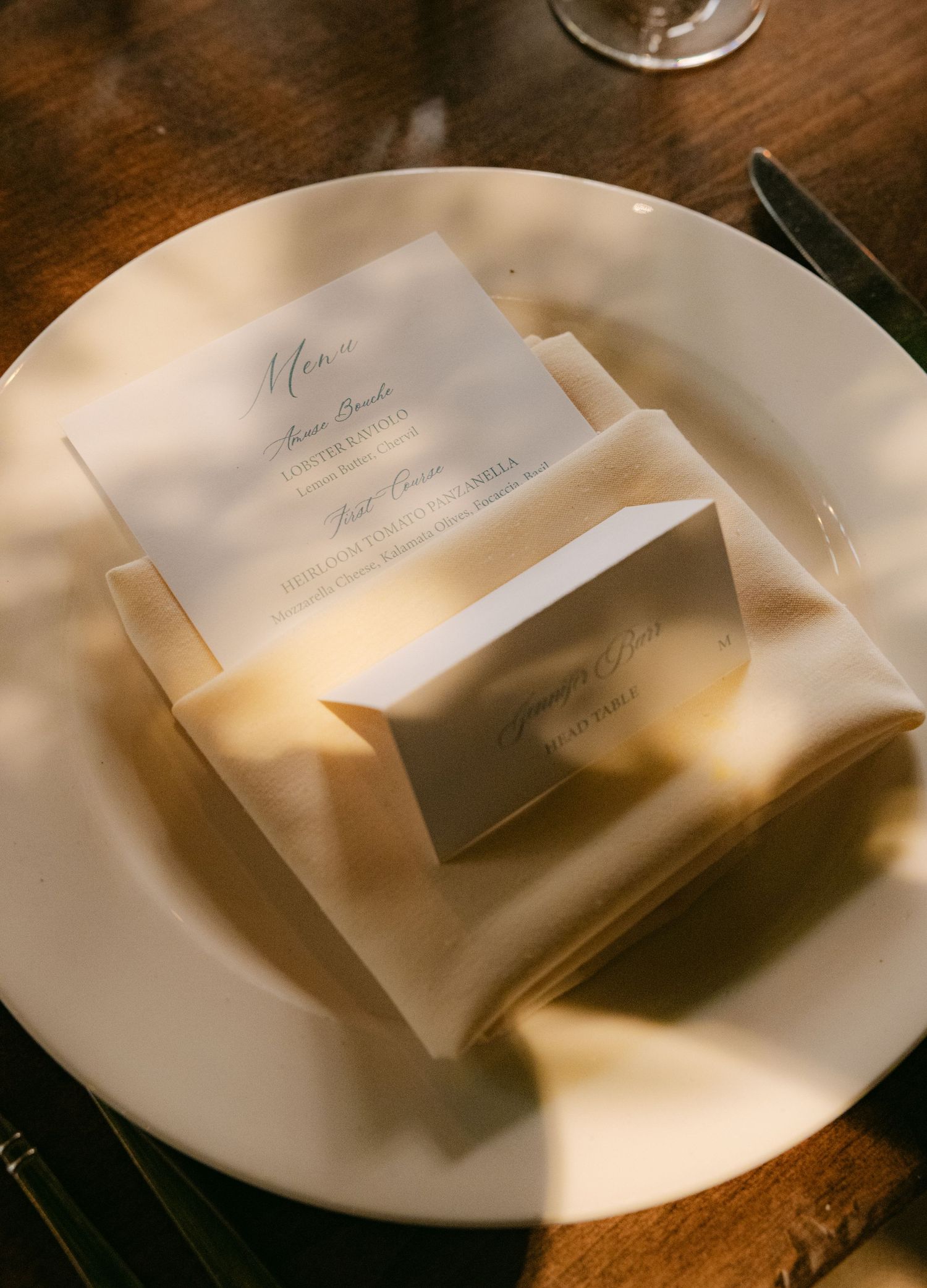 White menu cards elegantly placed on white plates at a formal table setting.