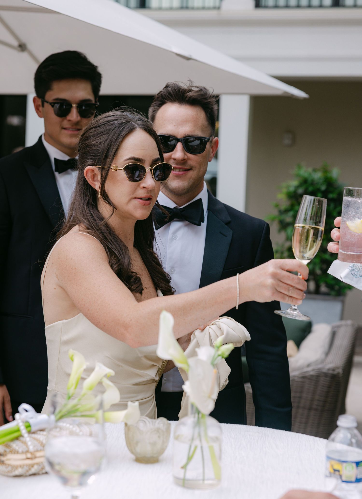 Elegant outdoor wedding reception with champagne toasts and formal attire.