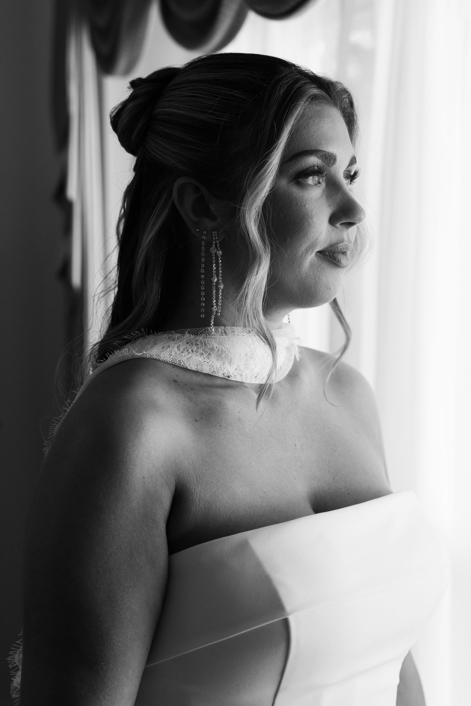 A series of black and white portraits showing a bride in soft window light looking to the side in contemplative poses.