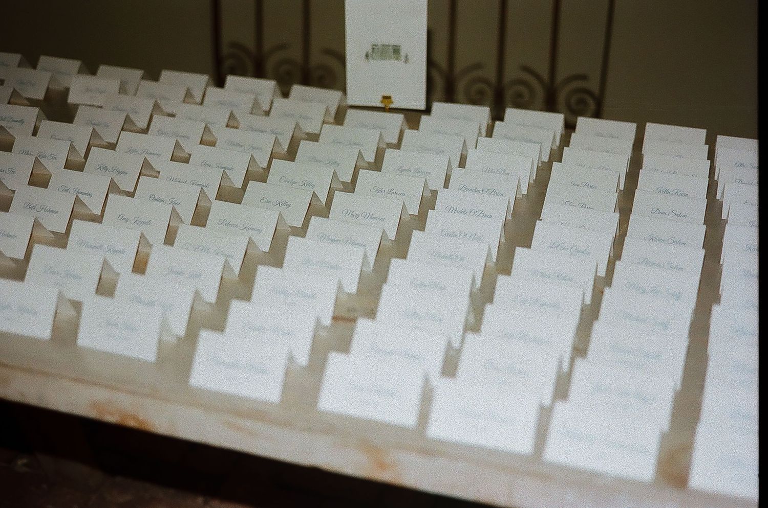 Rows of white place cards arranged for wedding reception seating.