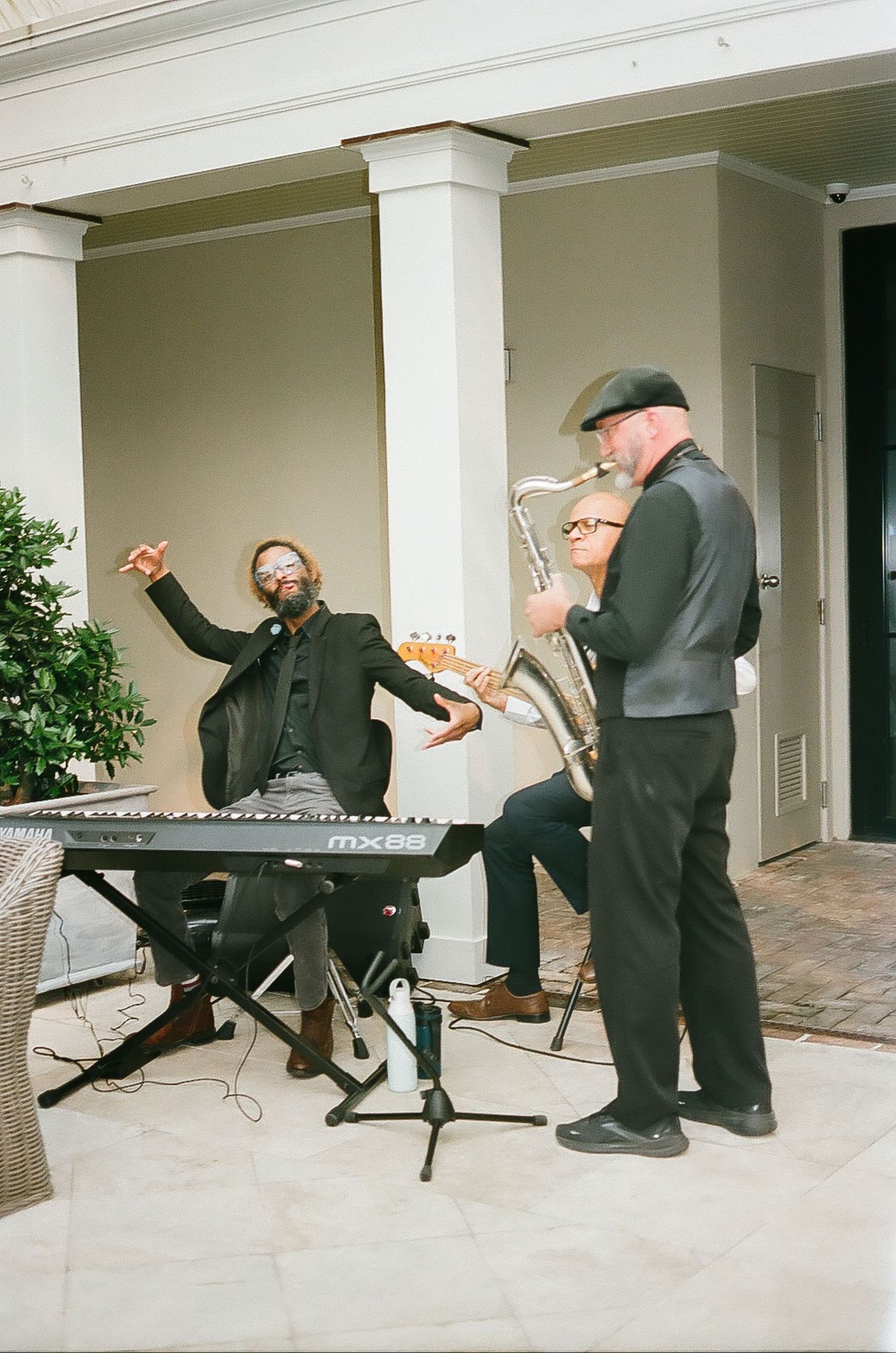 Musicians in black attire performing during an outdoor event.