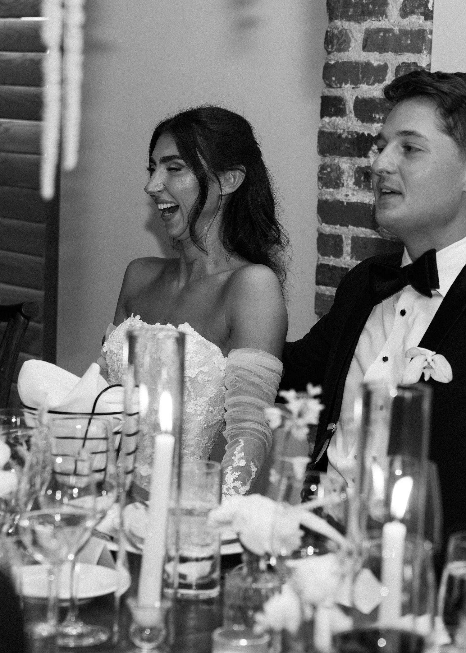 Wedding reception table setting with guests enjoying dinner and conversation.