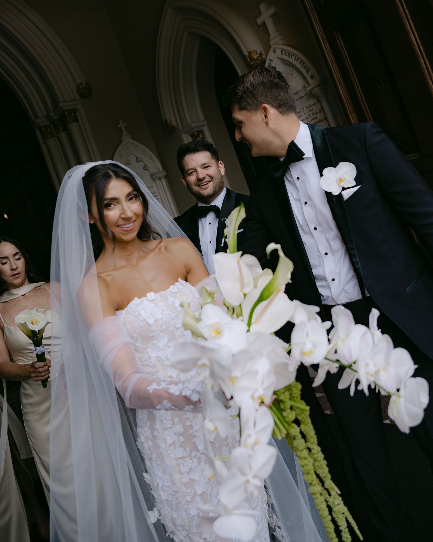 Wedding ceremony scenes showing intricate lace dress details and white orchid bouquet.