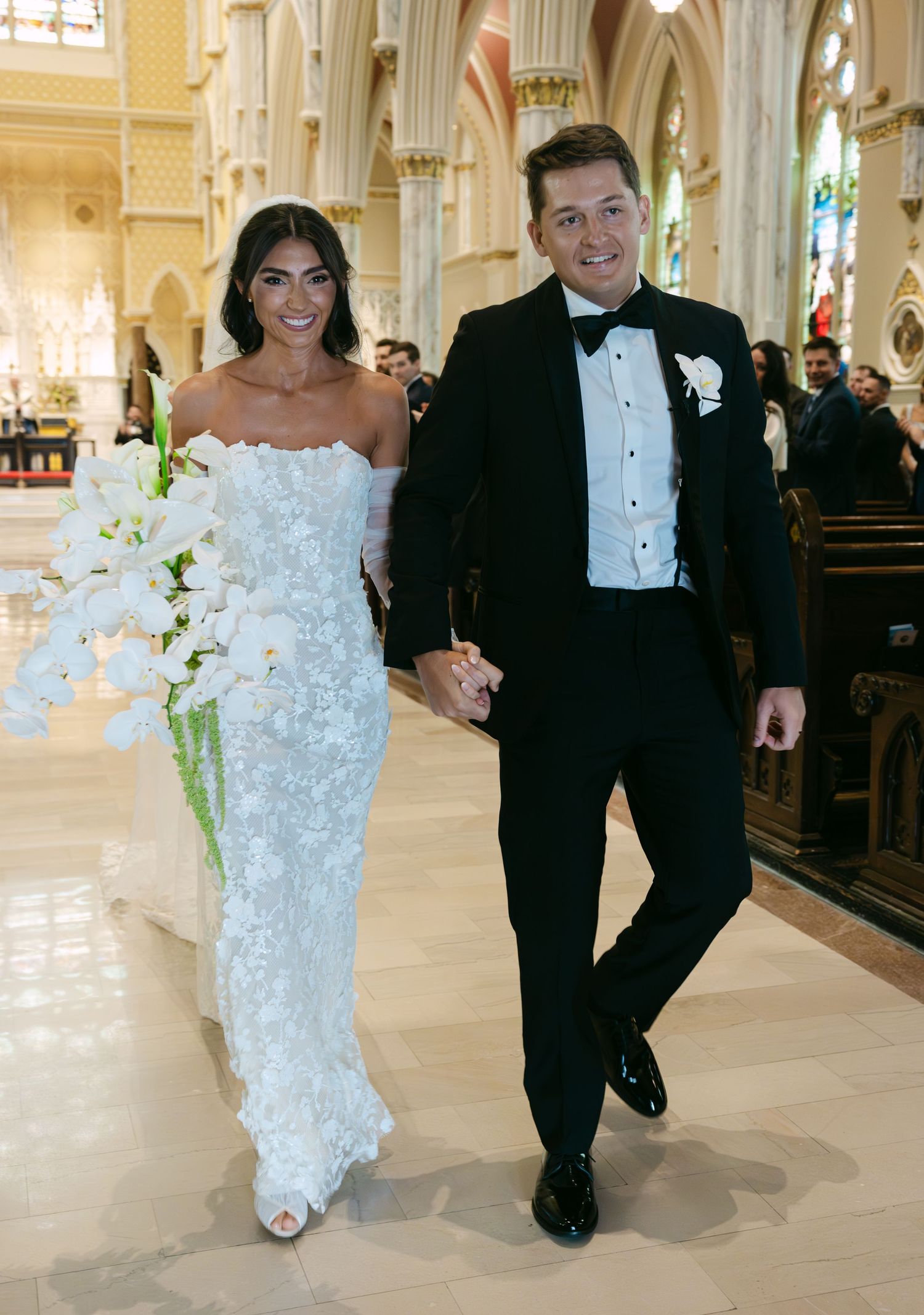 A newlywed couple walks down the church aisle after their wedding ceremony.