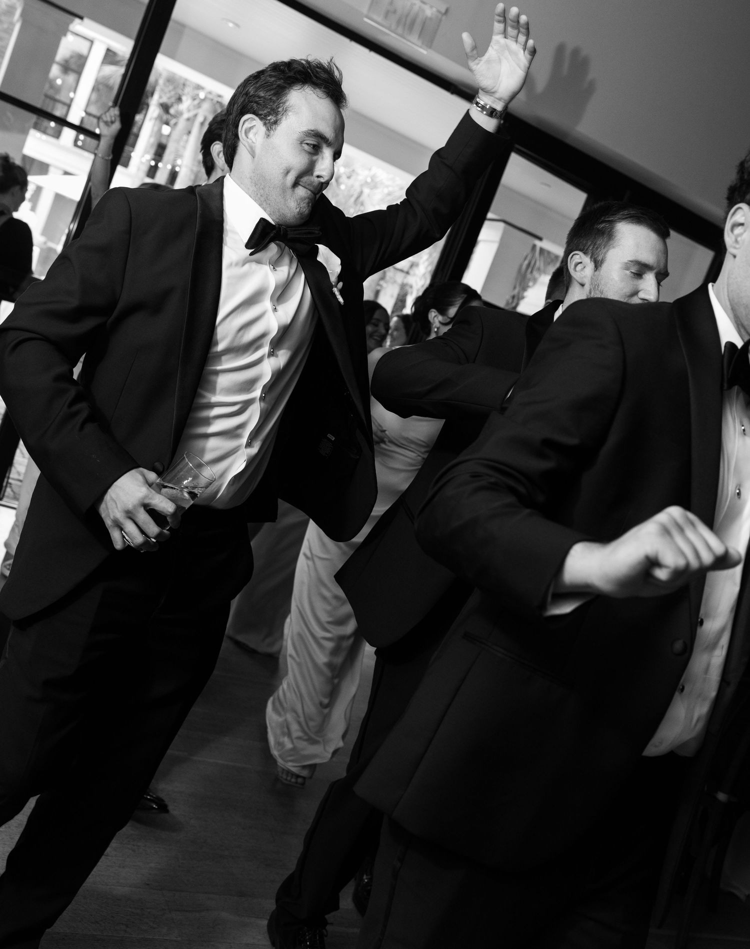 Black and white photos of wedding guests dancing and celebrating at reception.