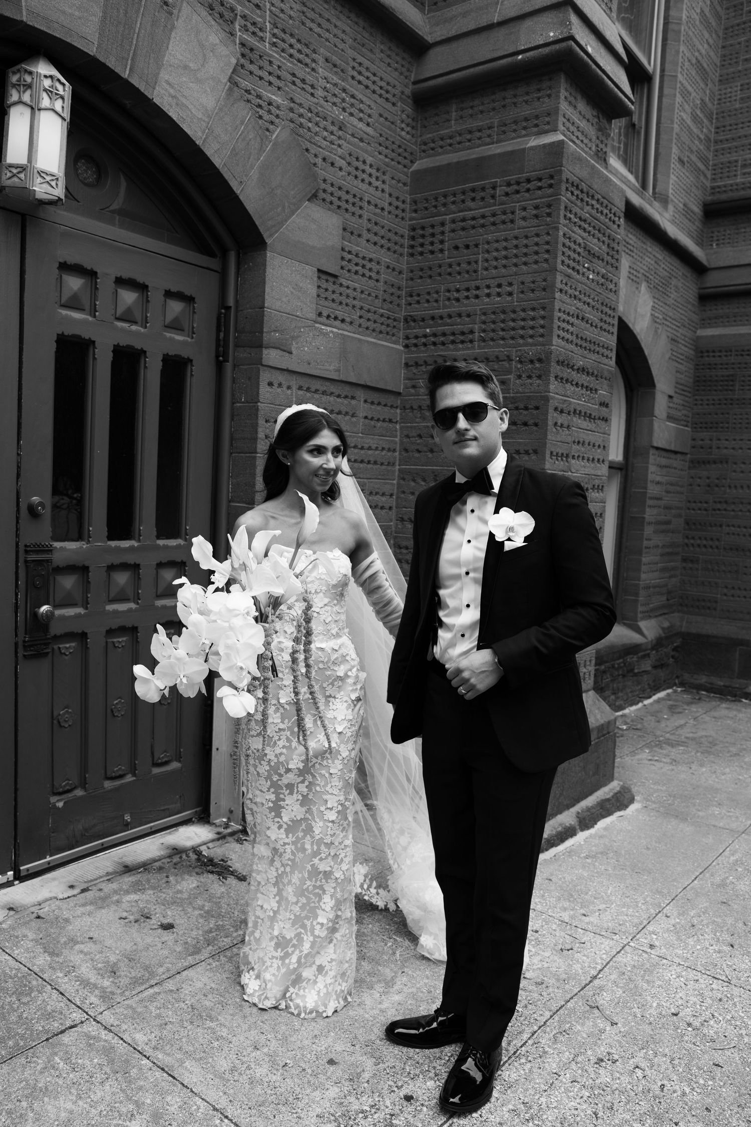 Black and white wedding photos showing couple posing against brick building exterior.