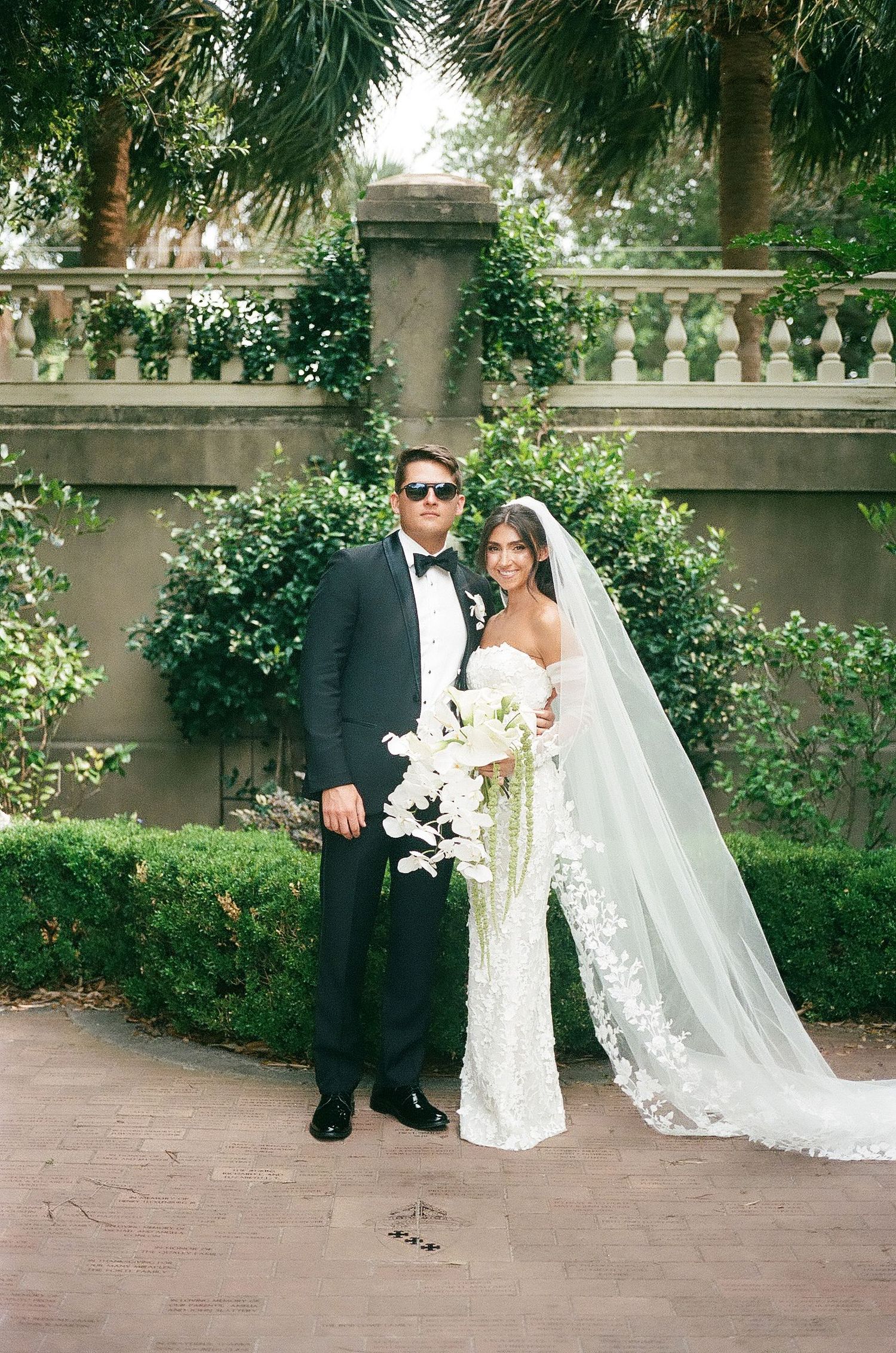 Romantic wedding photos in a garden setting with lace veil and white floral bouquet.