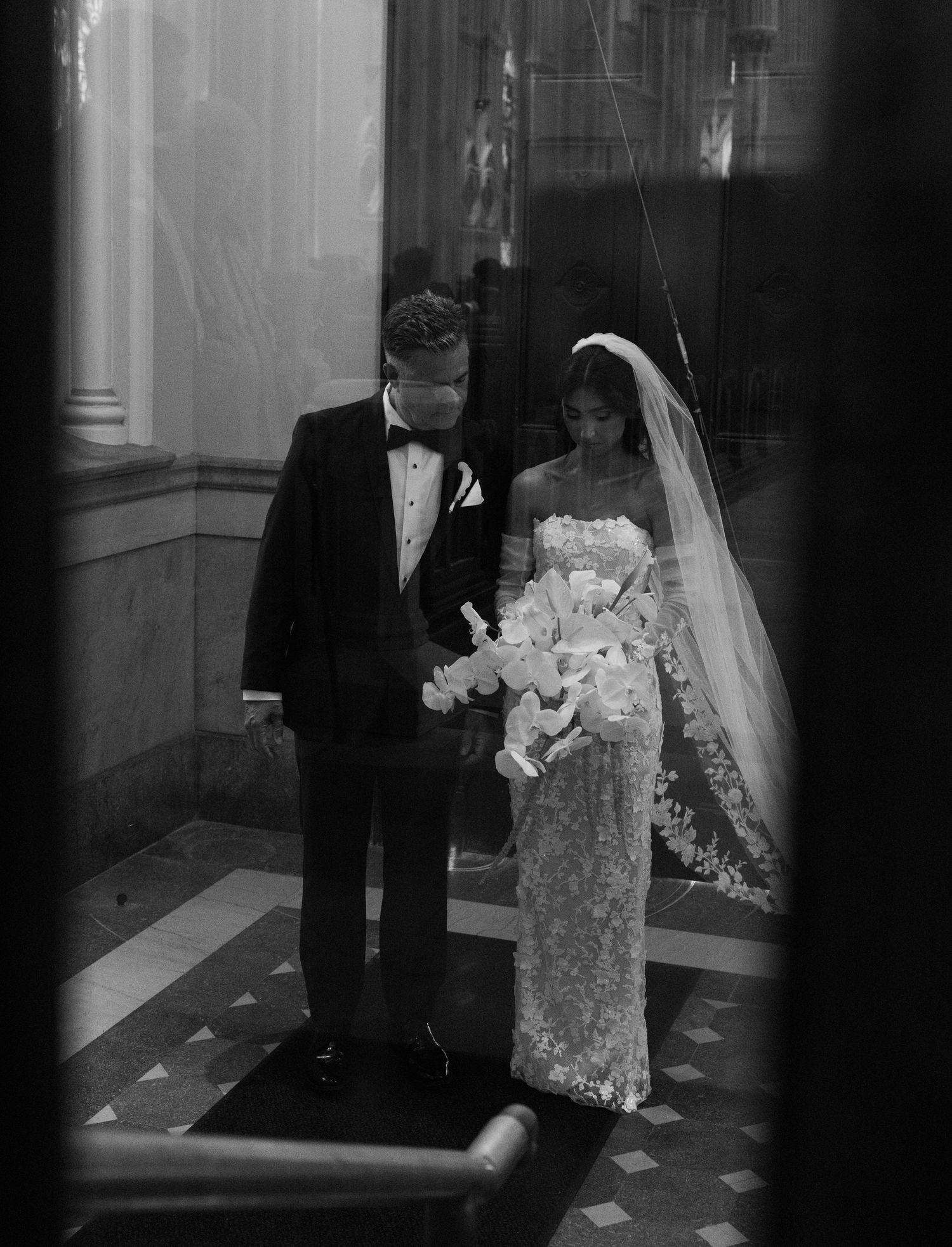 Black and white photo showing a procession through a church hallway.