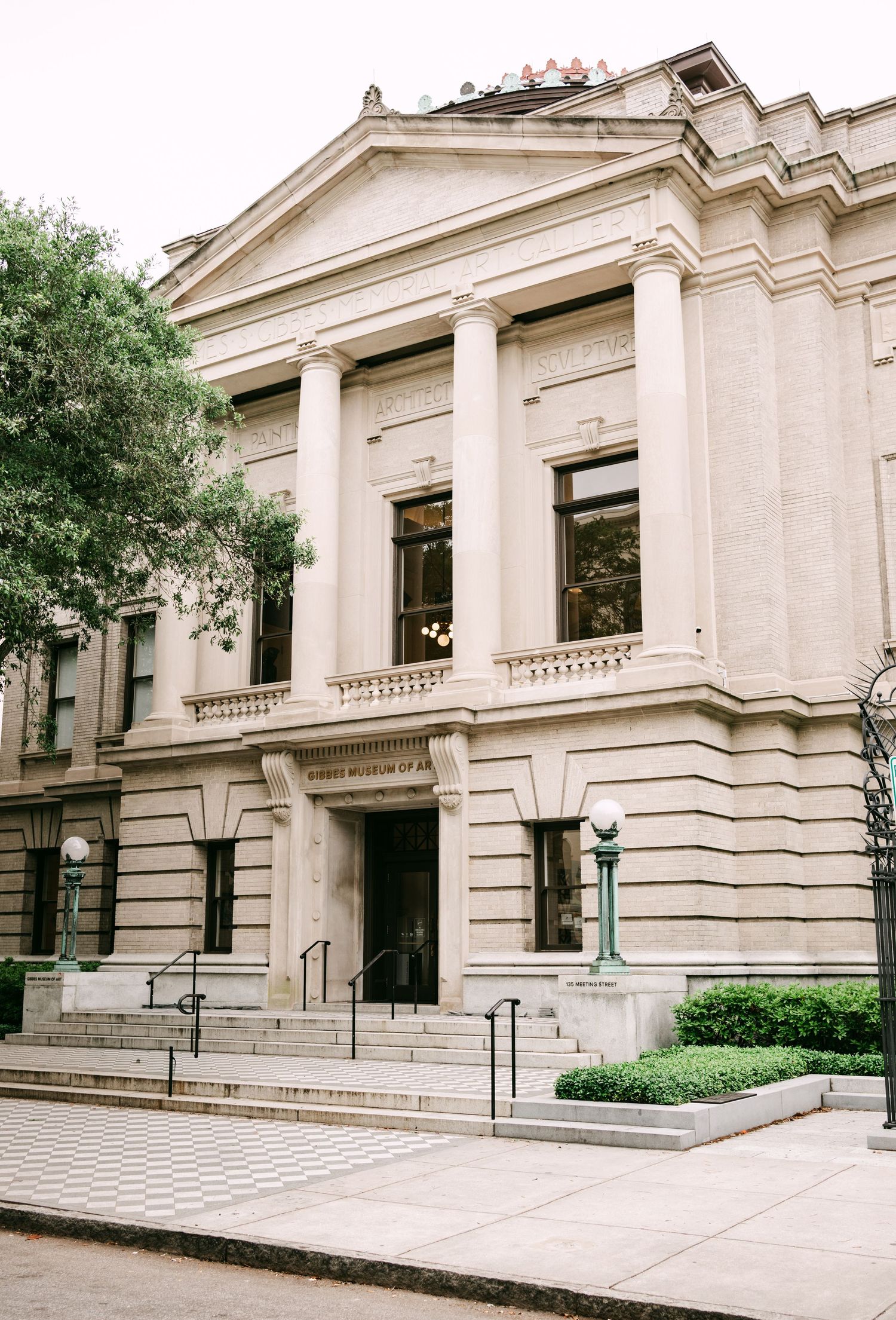 Neoclassical museum building with columns and stone steps in an urban setting.