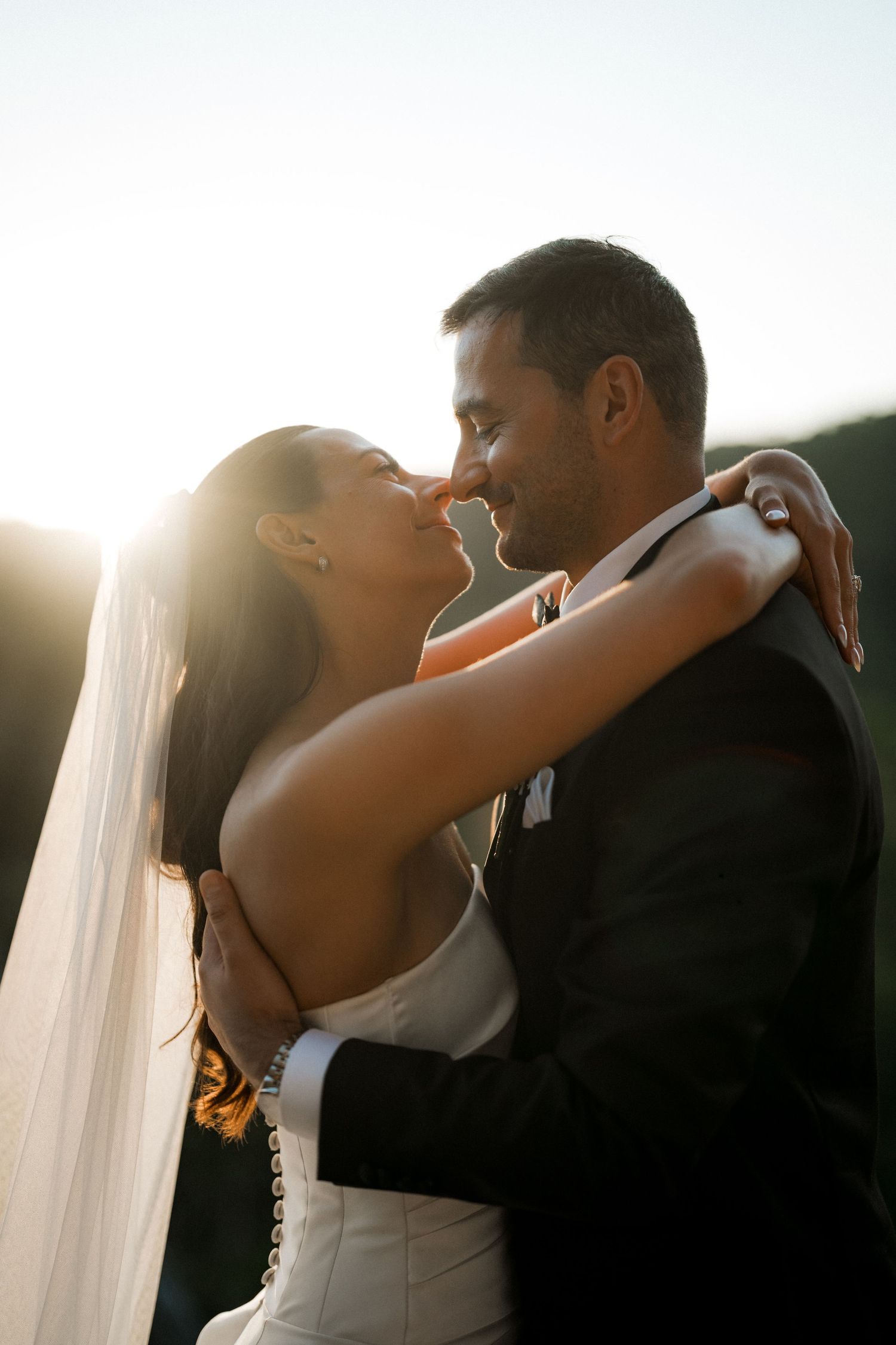 A romantic sunset moment between newlyweds as they embrace outdoors.
