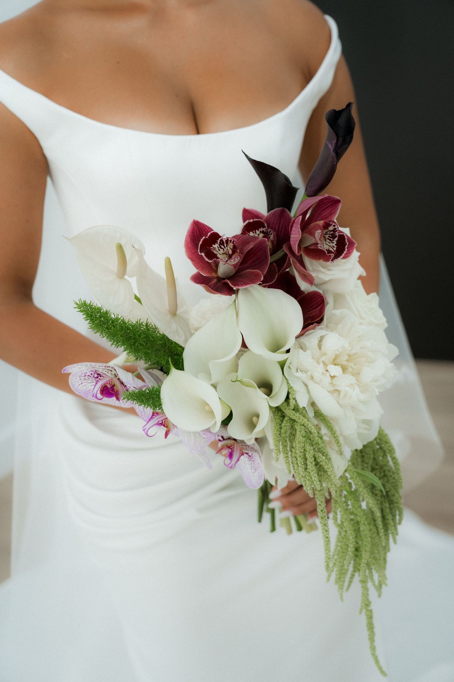 Close-up views of white wedding dress bodice adorned with burgundy orchids and cascading white floral arrangements.
